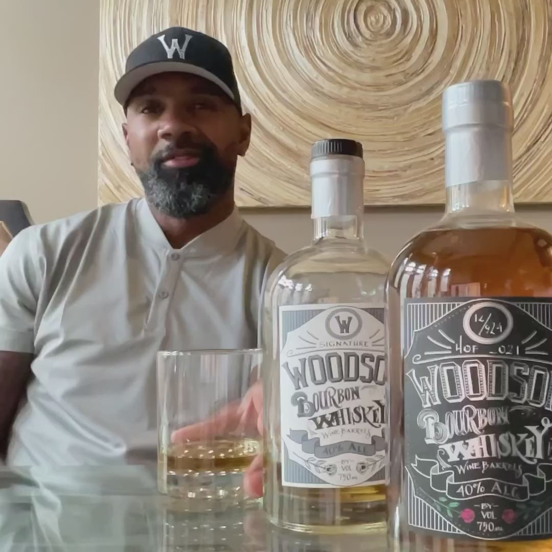 Woodson Whiskey Blue & Maize Signature Series Bourbon displayed with a glass of bourbon in a stylish setting.
