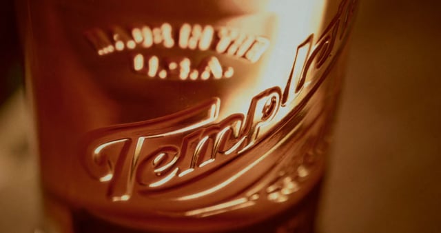Close-up of Templeton Rye whiskey bottle showcasing its label and rich amber color.