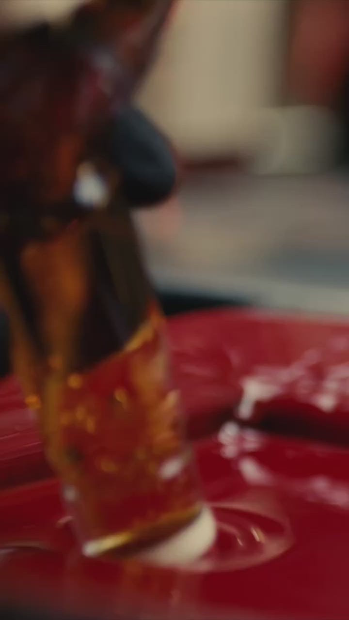 Close-up of a Maker's Mark Bourbon bottle being dipped in signature red wax.