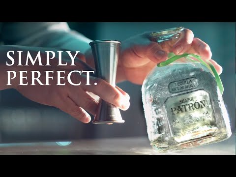 A hand pouring Patrón Silver Tequila from a bottle with a measurement jigger, showcasing the label 'Simply Perfect'.