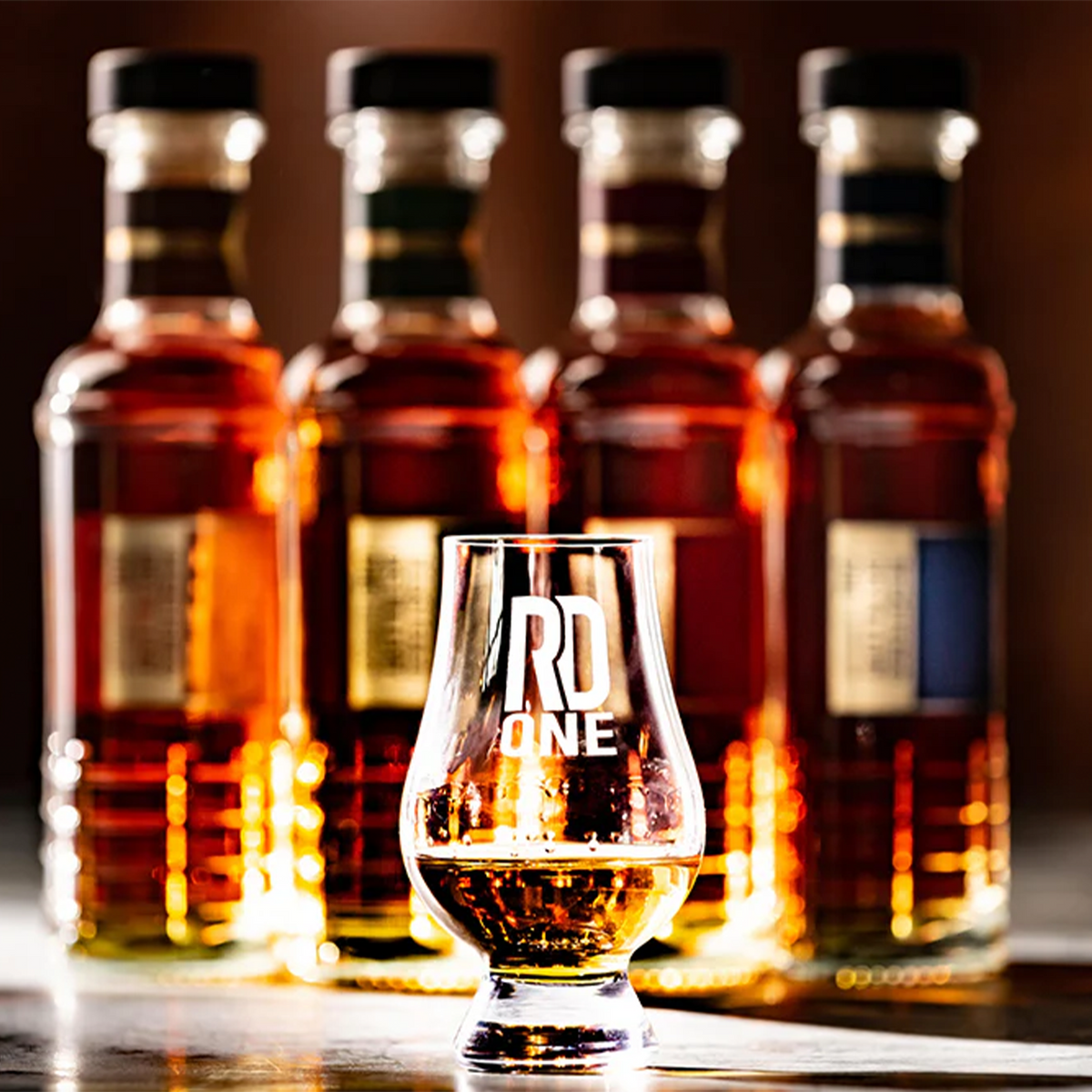 RD1 Double Oak & Maple Straight Bourbon bottle lineup with a tasting glass in foreground.