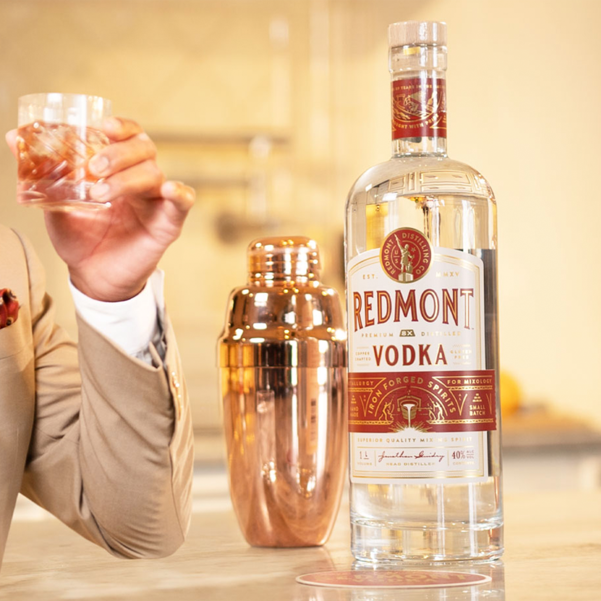 Redmont Vodka bottle on a bar with a shaker and a glass, showcasing its premium quality and smooth finish.