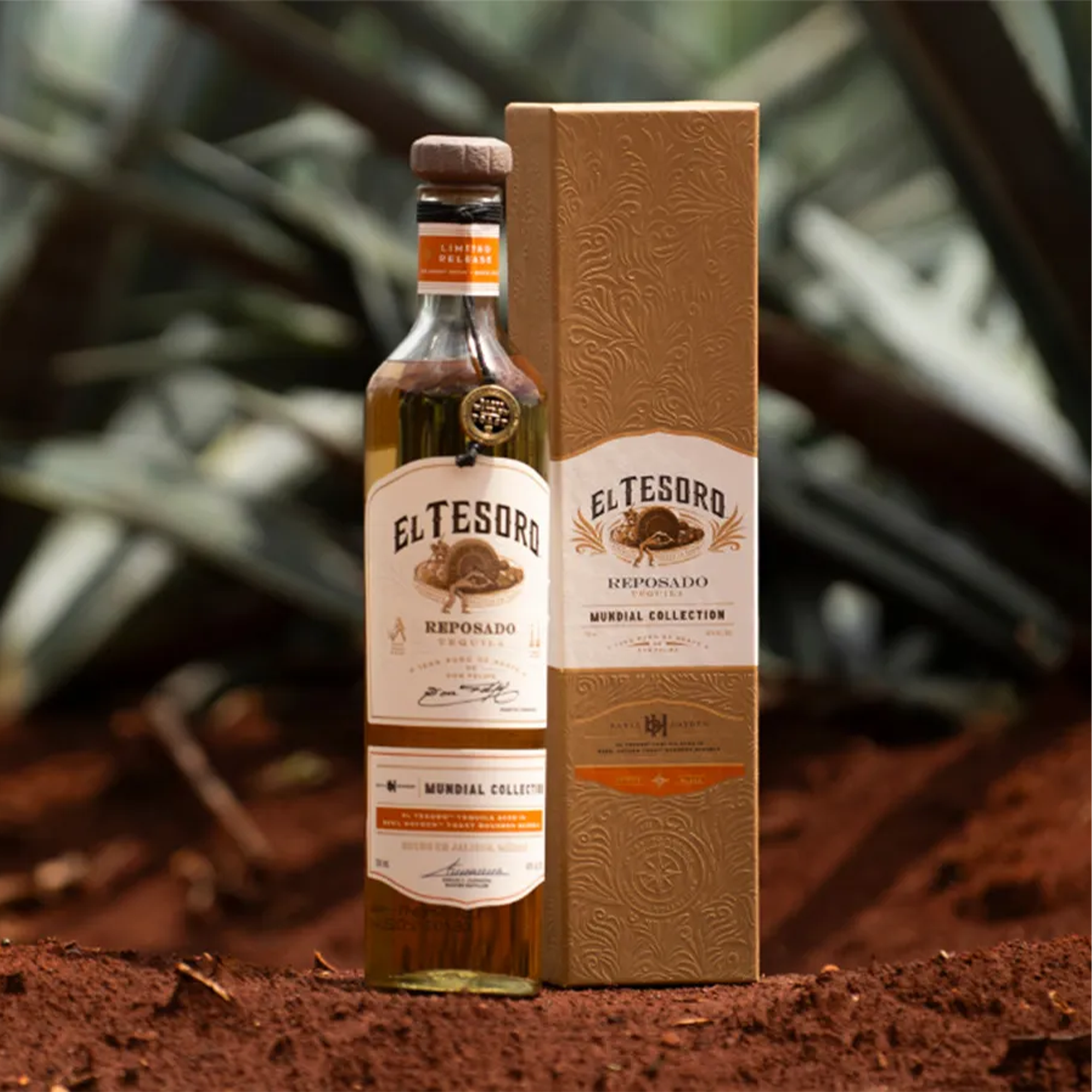 El Tesoro Mundial Collection Reposado Tequila bottle and packaging against an agave background.
