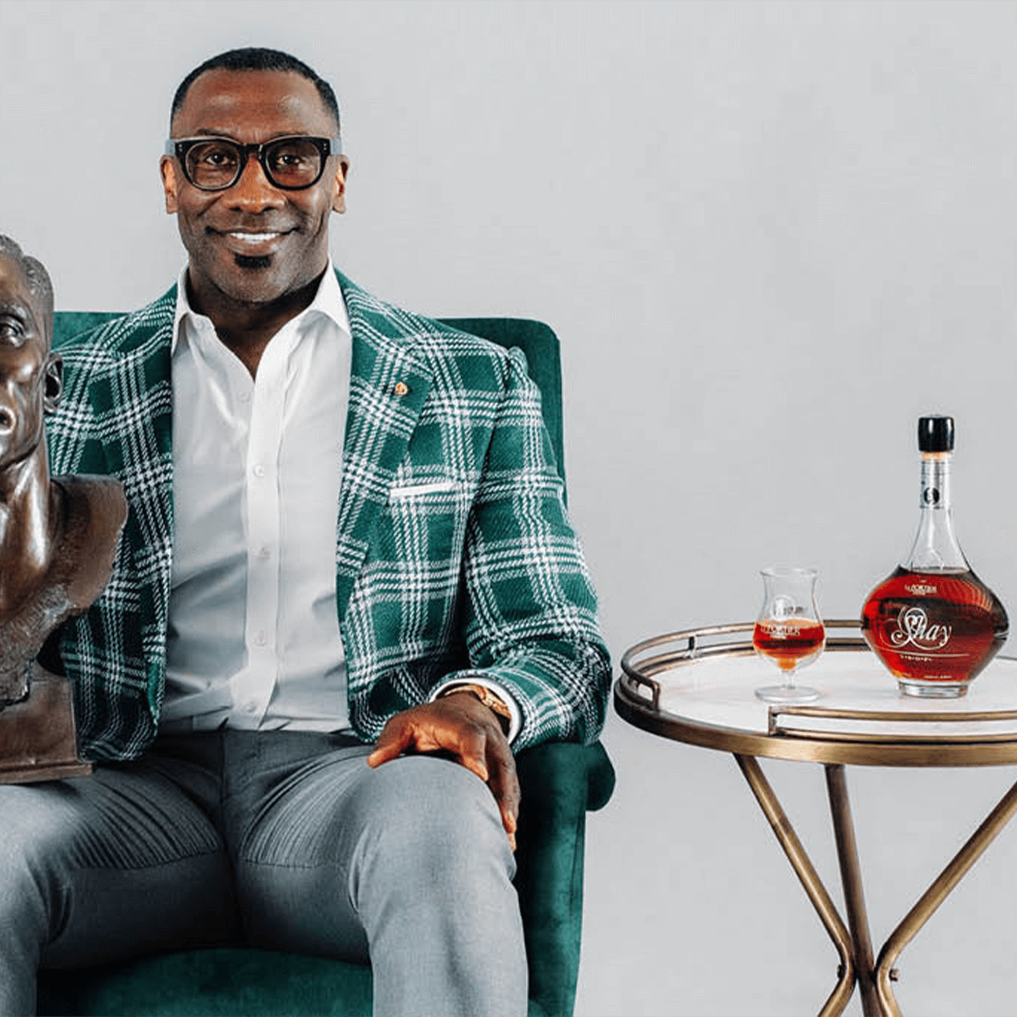 Shannon Sharpe sits with Le Portier Shay Collector Edition 2024 VSOP Cognac on a table beside him.