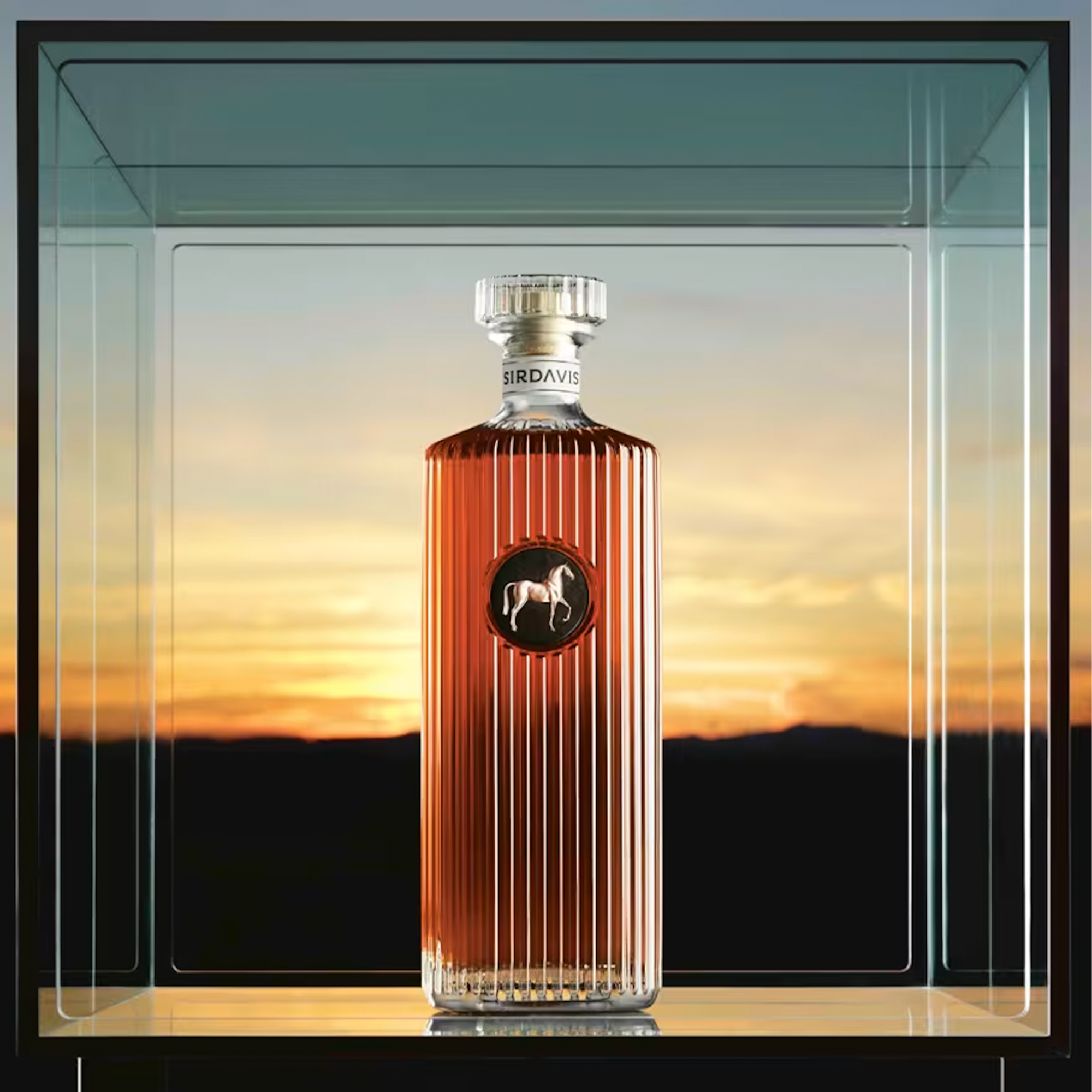 SirDavis American Whisky bottle displayed in a glass case with a sunset background, showcasing premium craftsmanship.