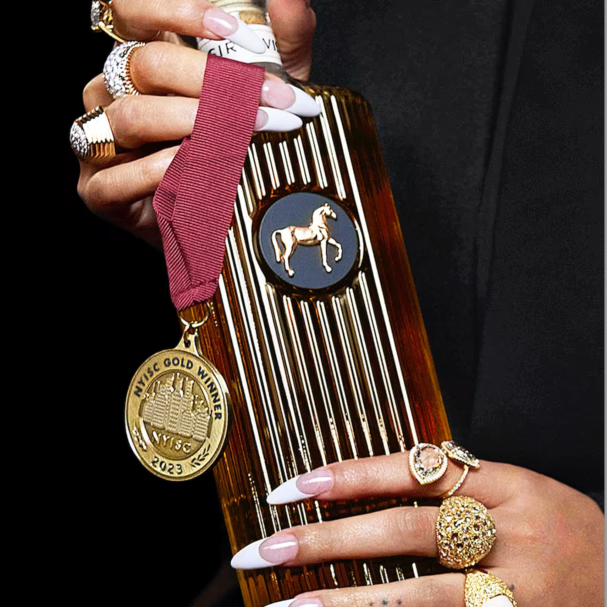 Hand holding SirDavis whisky bottle with gold medal, showcasing award-winning craftsmanship and luxury design.