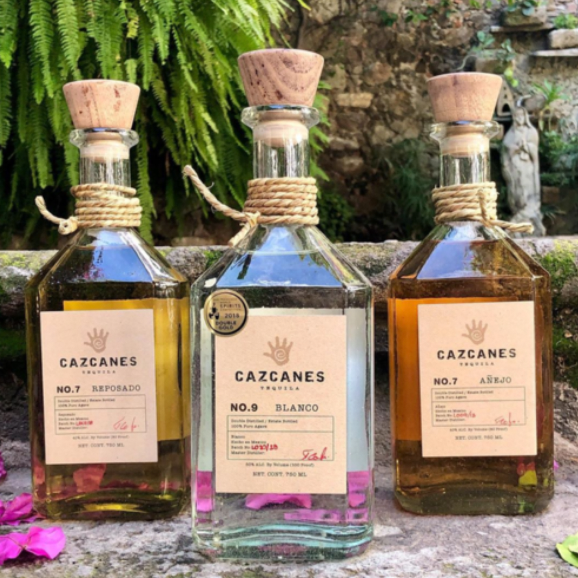 Cazcanes No.7 Añejo Tequila bottle displayed with Reposado and Blanco in a natural setting.