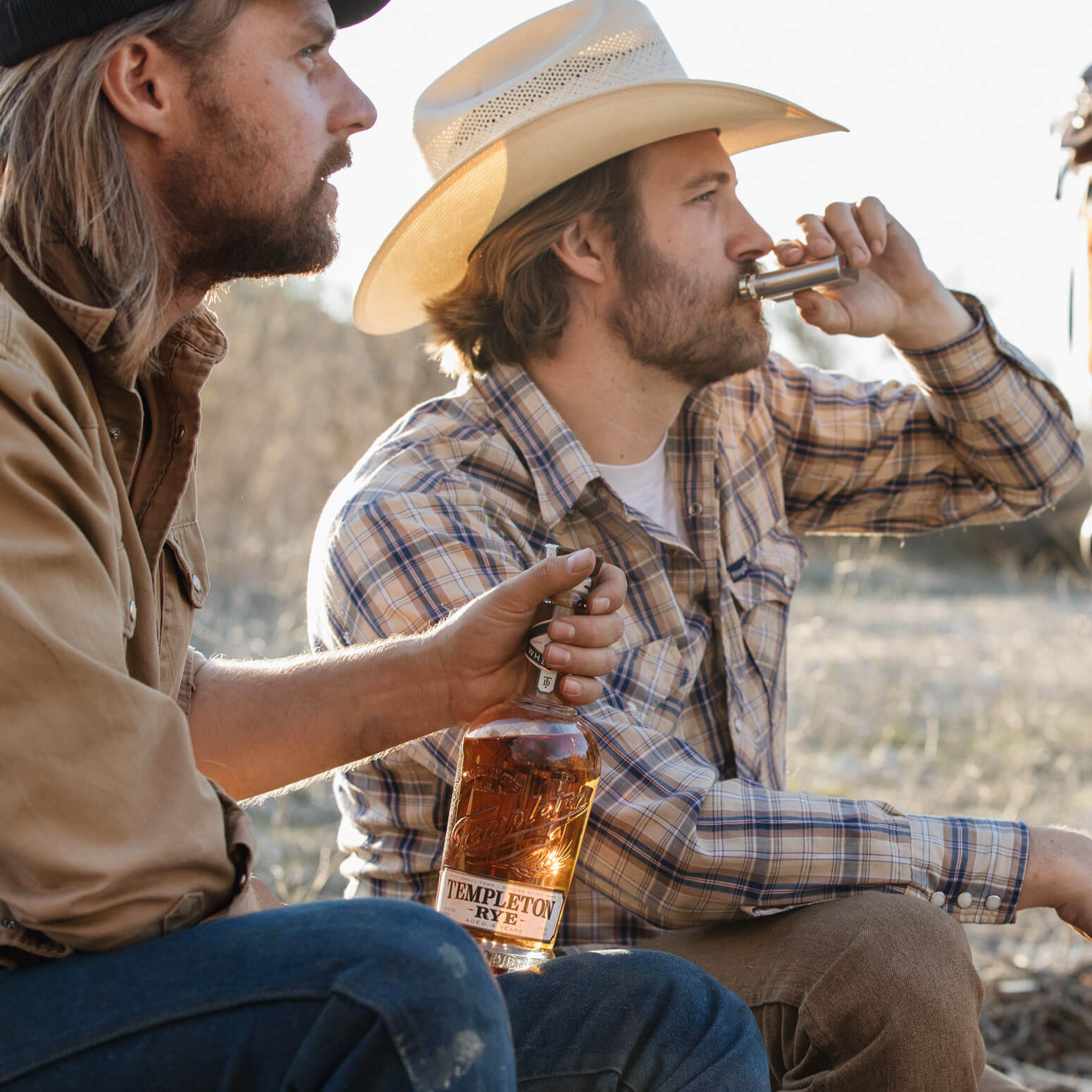 Two men enjoying Templeton Rye 4 year whiskey outdoors, highlighting the spirit's bold flavor and American heritage.