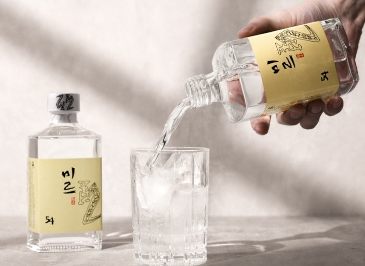Pouring Sulseam Mir 22 Soju into a glass with ice, showcasing the traditional Korean spirit.
