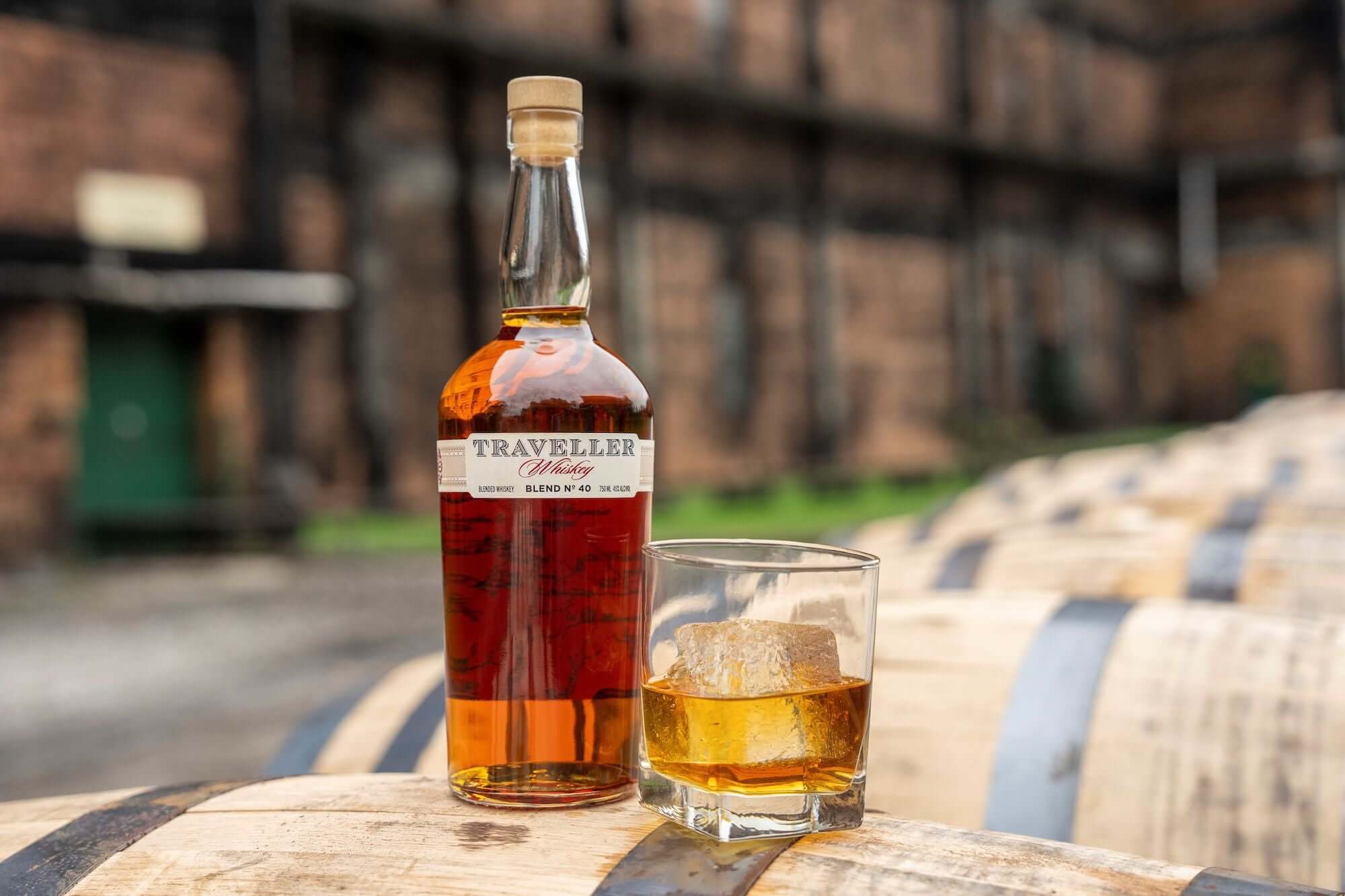 Traveller Whiskey Blend No. 40 with a glass of whiskey on a barrel background.