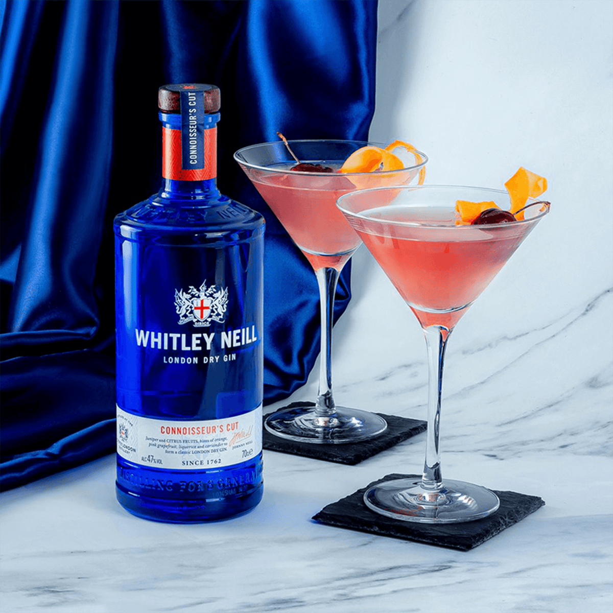 Whitley Neill Connoisseur's Cut London Dry Gin with elegant cocktails garnished with orange and cherry.