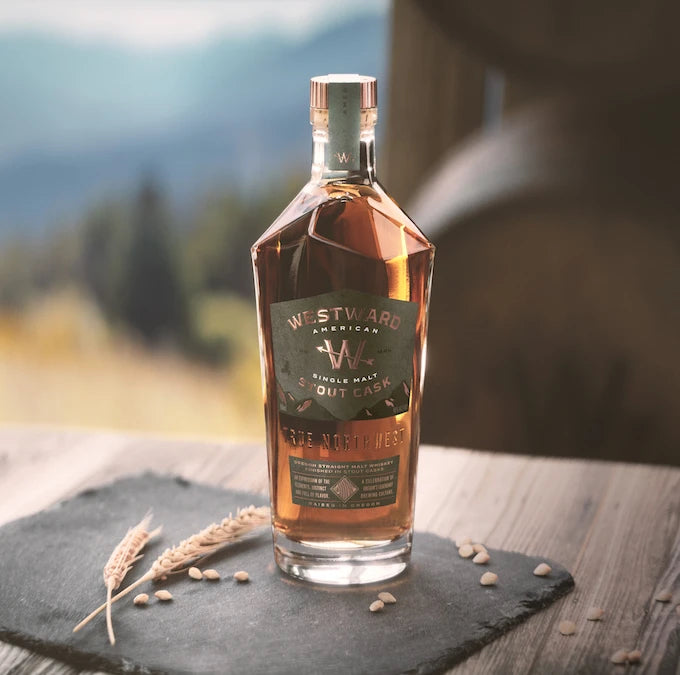 Westward American Single Malt Stout Edition whiskey bottle on slate with wheat and pine background.