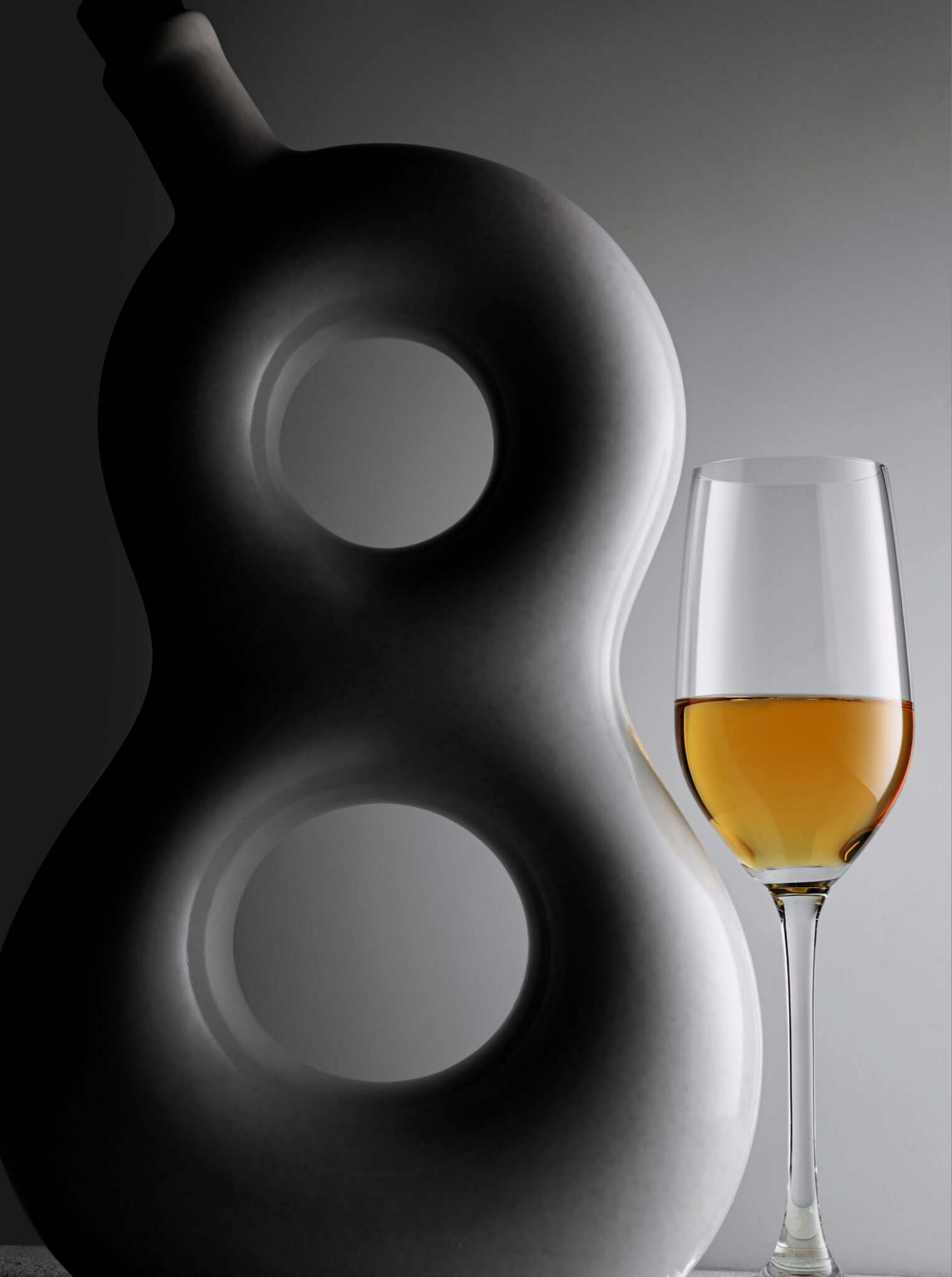 Elegant Eight Reserve Añejo Tequila bottle beside a glass showcasing its rich amber color.