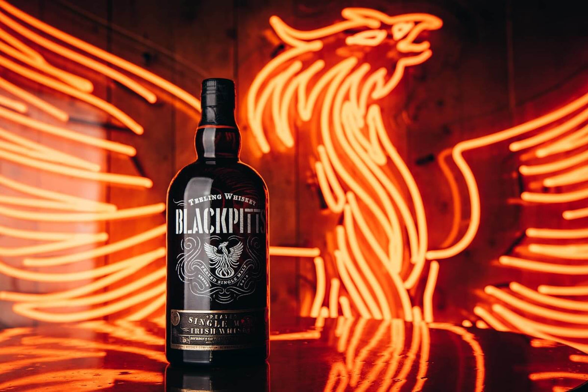 Teeling Blackpitts Peated Single Malt Irish Whisky bottle with neon phoenix backdrop