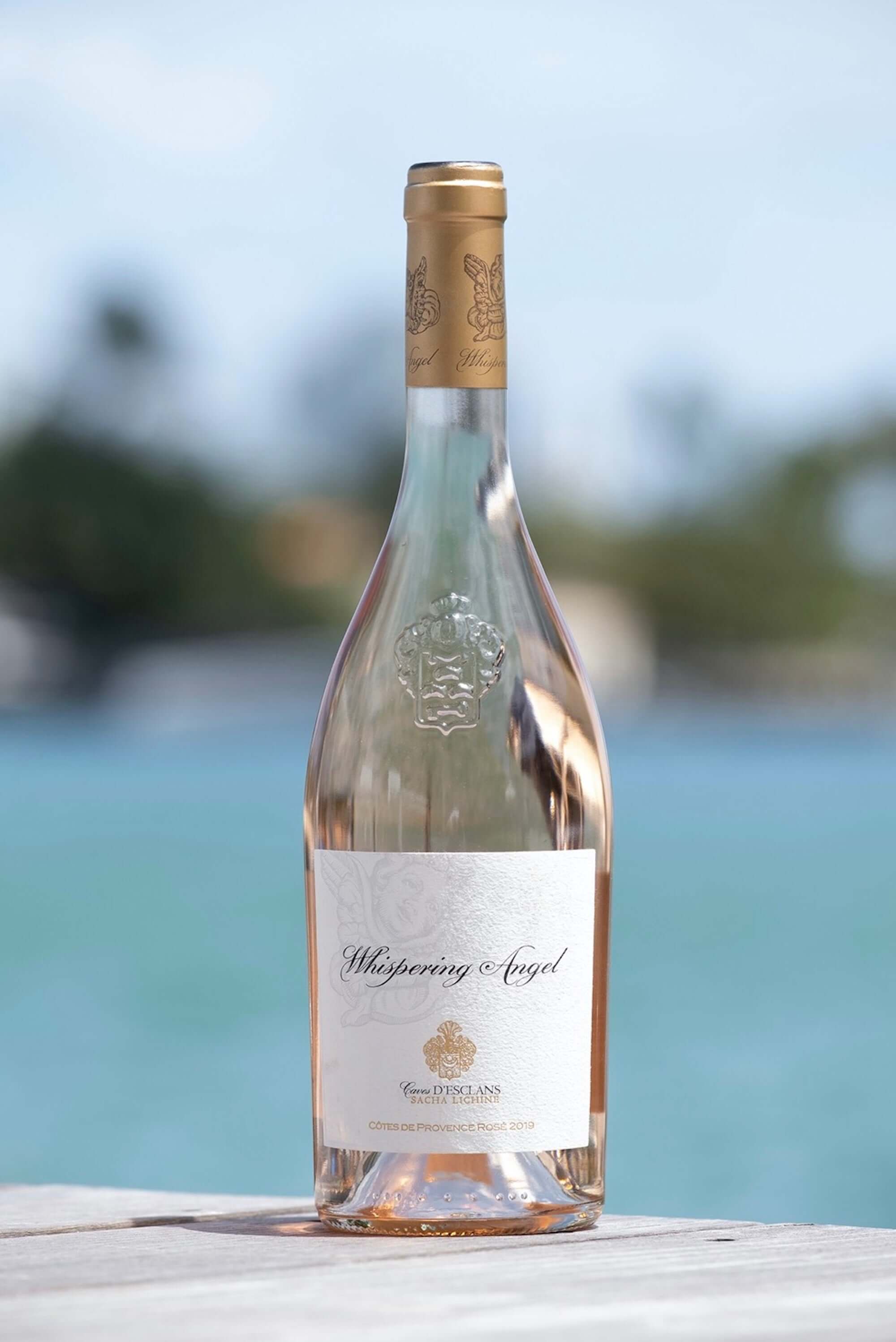 Château D'esclans Whispering Angel Rosé bottle against a scenic water background, 750ml premium Provence wine.