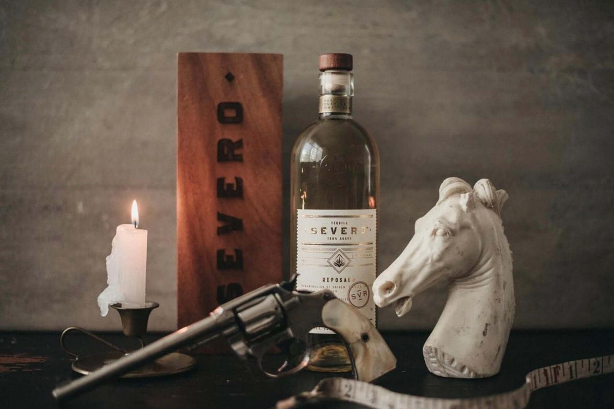 Severo Reposado Tequila bottle with candle, revolver, and horse statue, evoking Mexico's Maximato era.