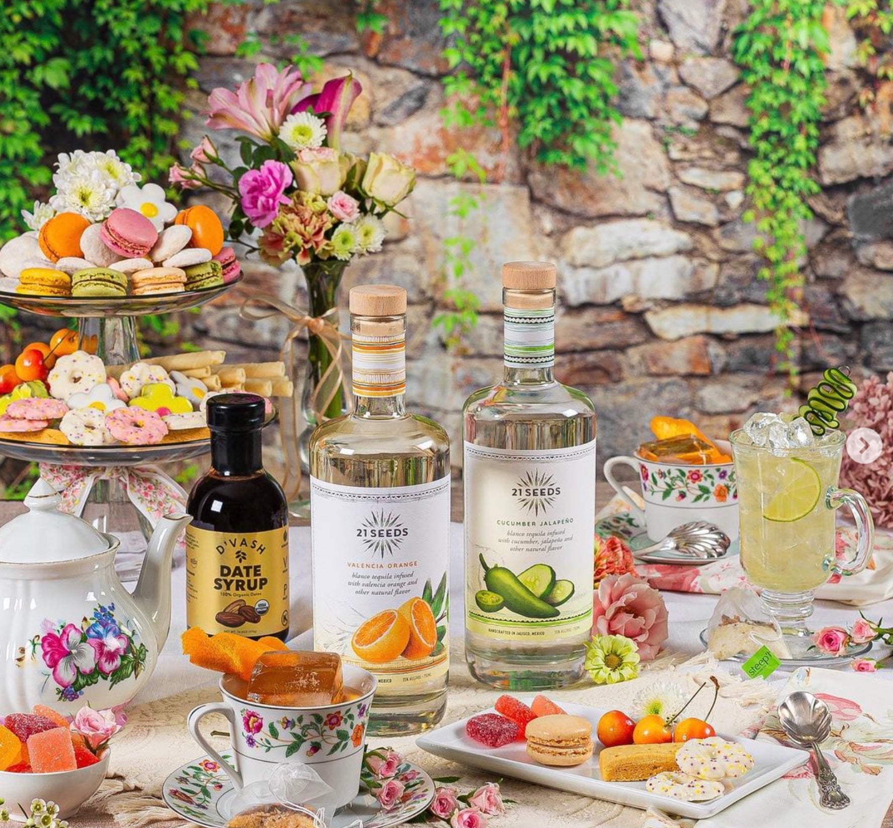 Elegant spread featuring 21Seeds Cucumber Jalapeño Tequila with desserts and floral decor.