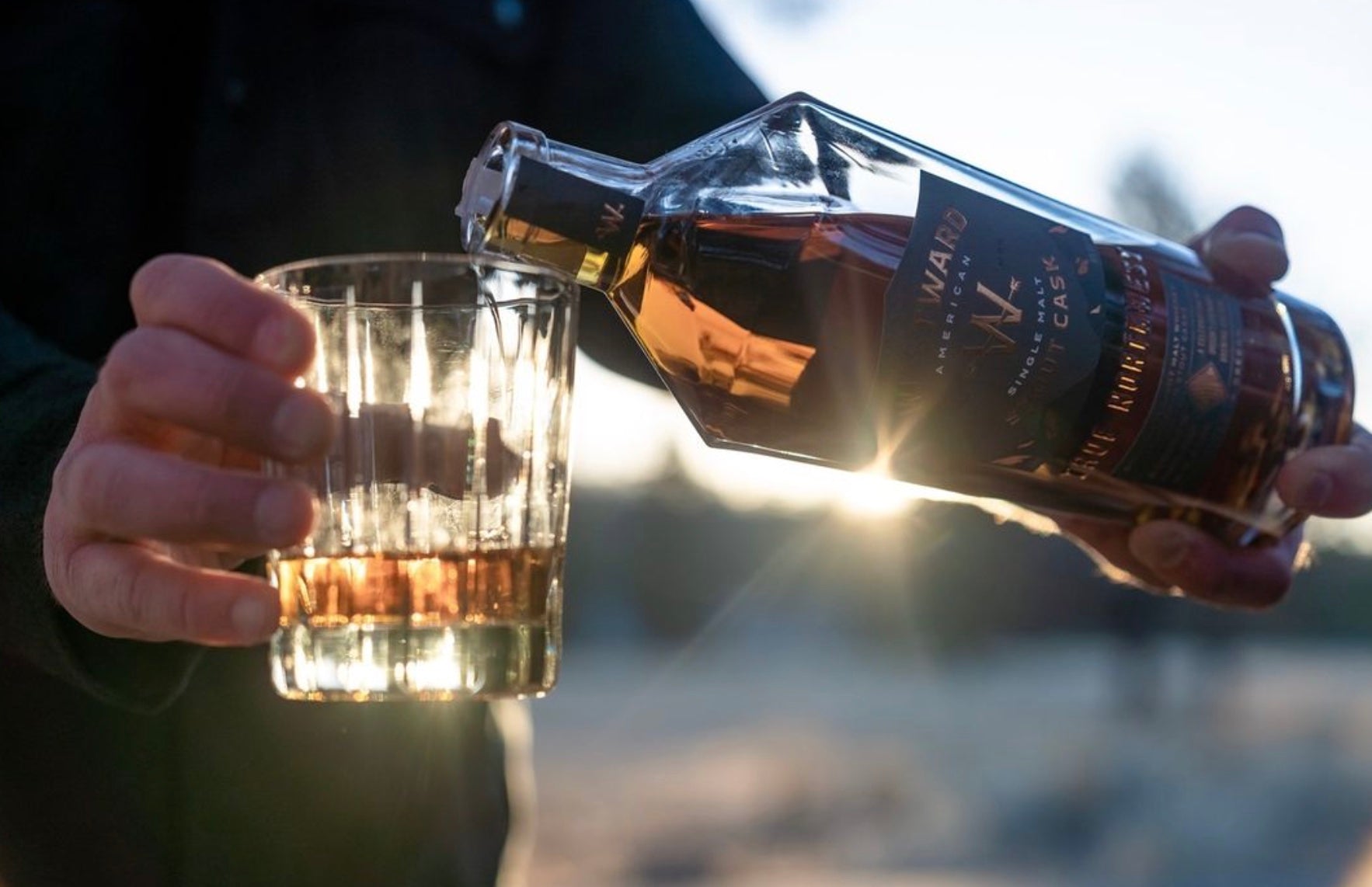 Pouring Westward American Single Malt whiskey into a glass, showcasing Oregon's brewing culture.