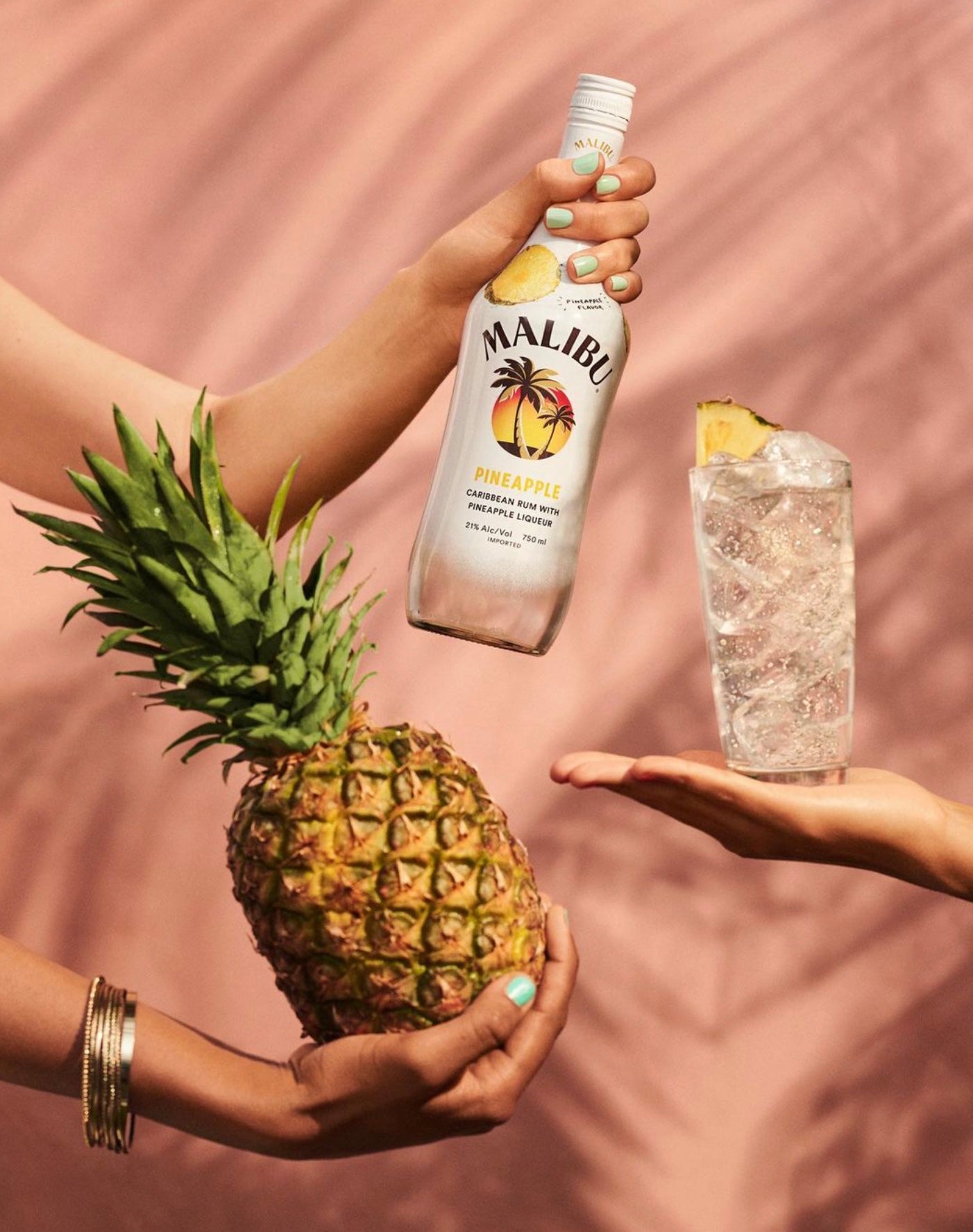 Malibu Rum Pineapple bottle with pineapple and cocktail glass, perfect for tropical drinks like piña coladas.