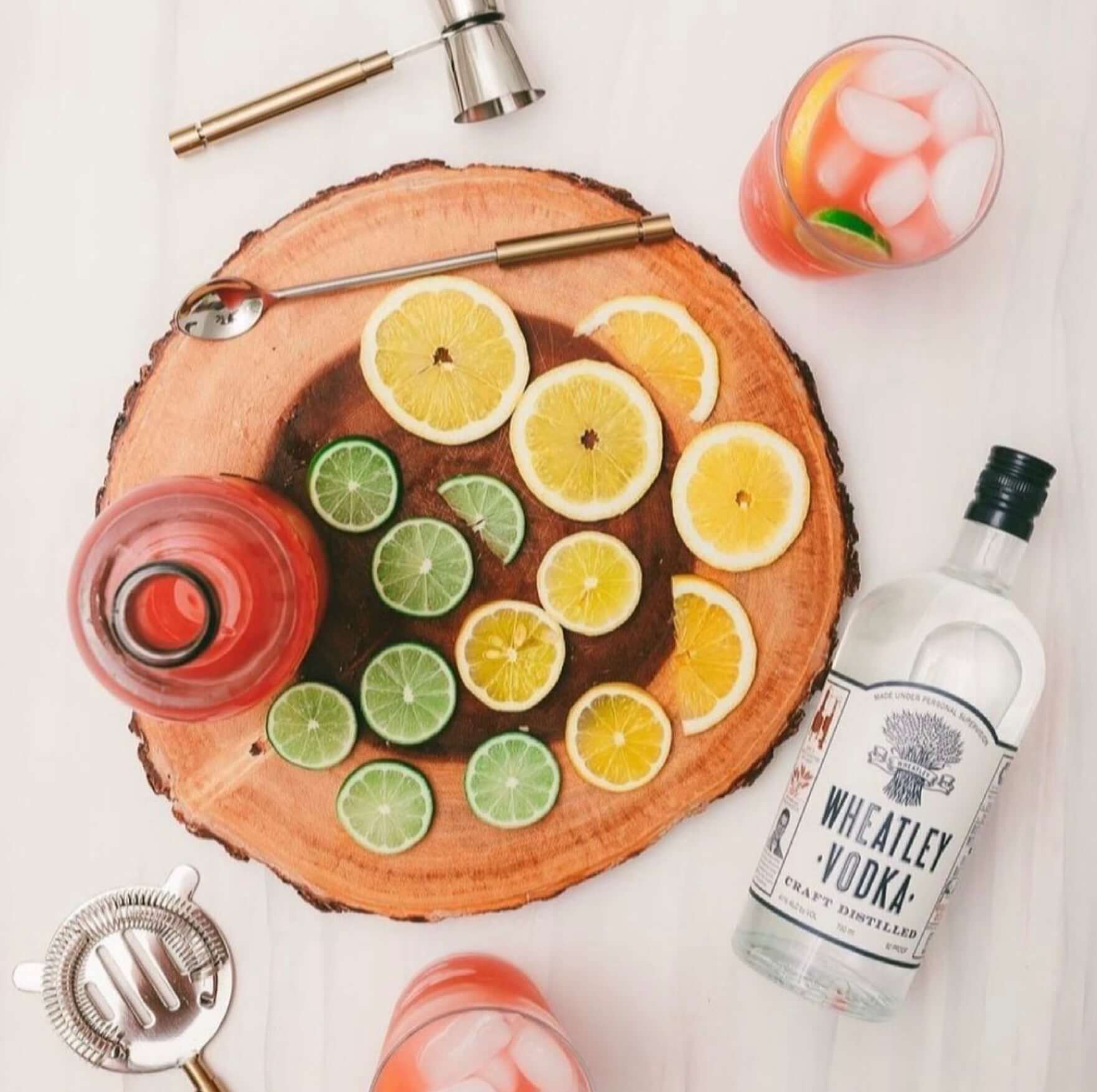 Wheatley Vodka by Buffalo Trace with fresh citrus slices on a wooden serving board, perfect for cocktails.