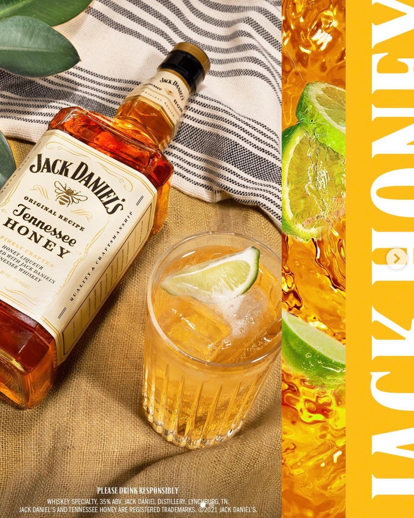 Bottle of Jack Daniel's Tennessee Honey whiskey beside a glass with cocktail and lime, showcasing a smooth blend.