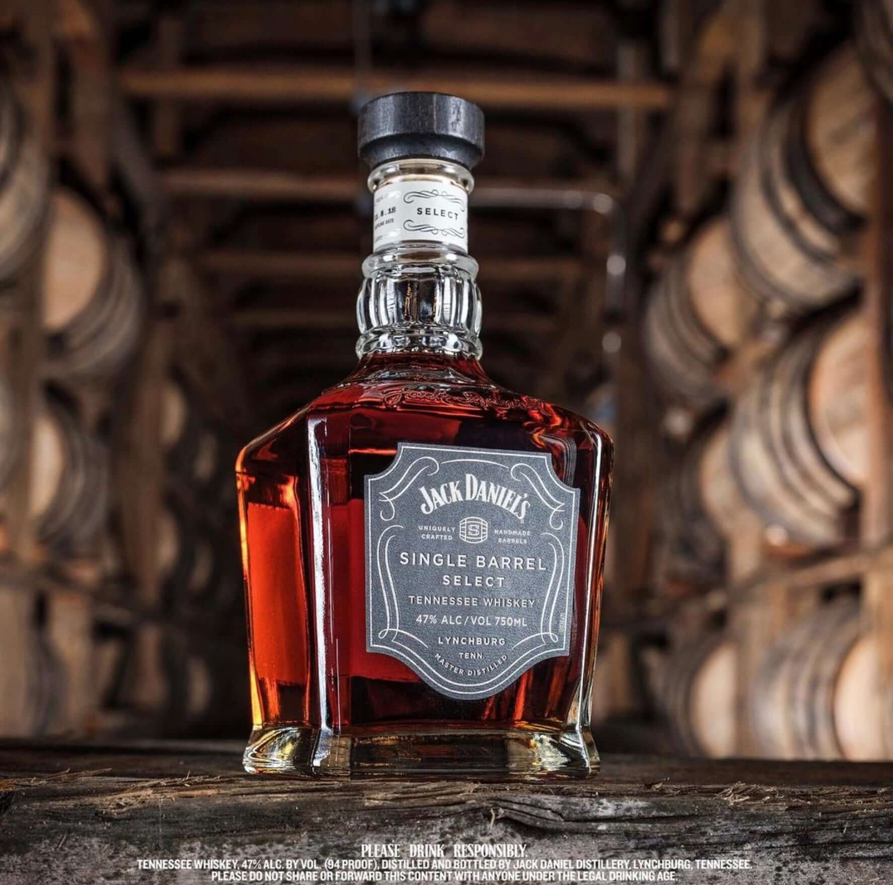 Jack Daniel's Single Barrel Select whiskey bottle showcasing rich color and elegant design against a barrel backdrop.