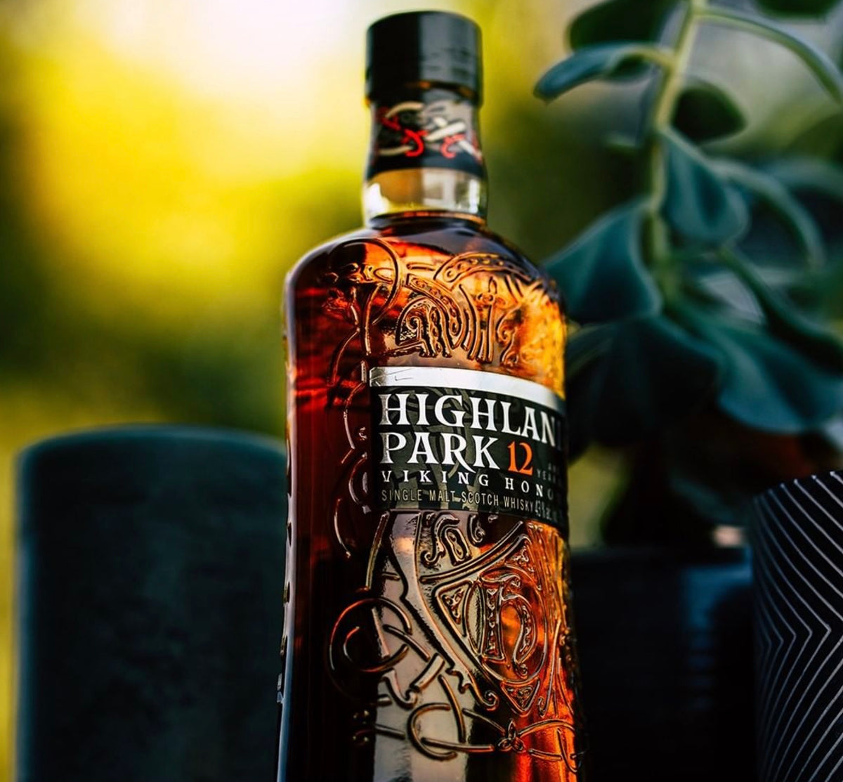 Highland Park 12 Year Old single malt whisky bottle, rich amber color with intricate Viking designs.