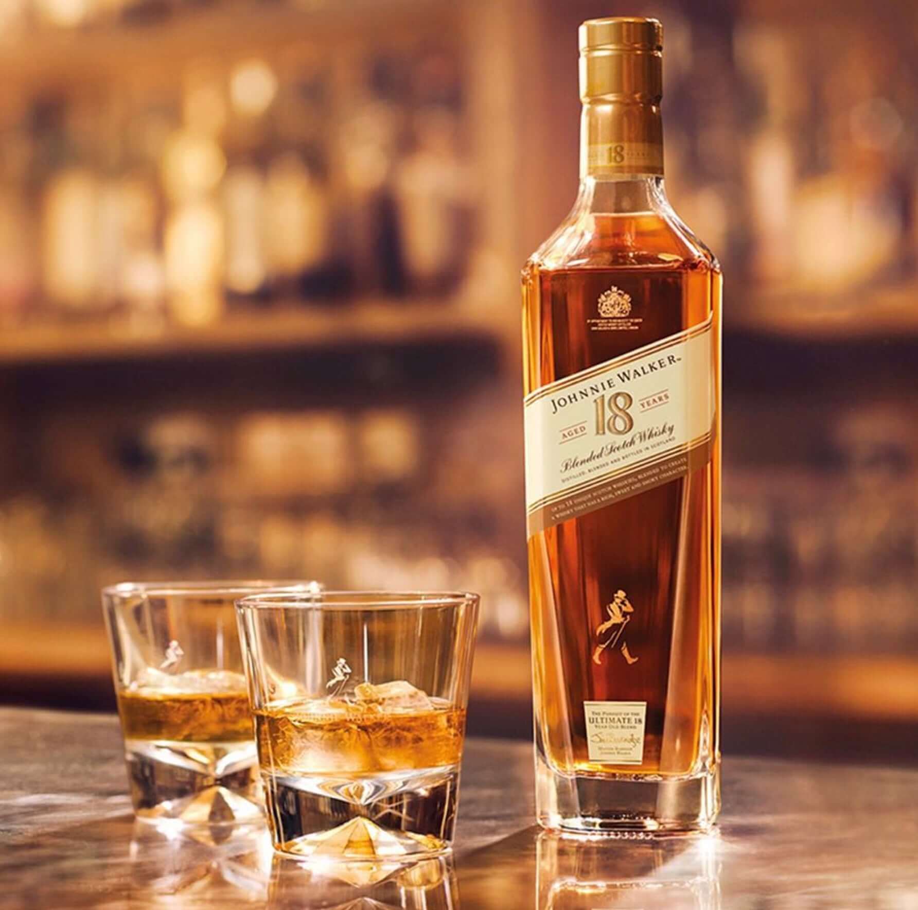 Johnnie Walker 18 Year Scotch bottle with two glasses of whisky on a bar, showcasing luxury and celebration.