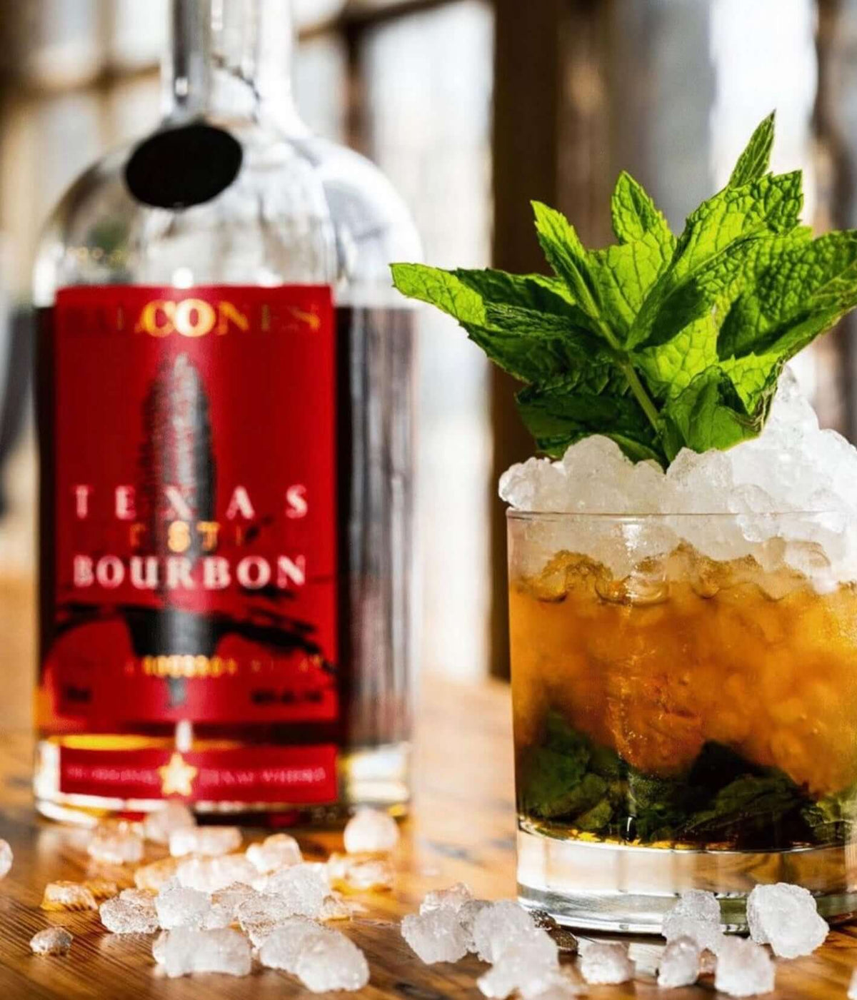 Balcones Texas Pot Still Bourbon bottle next to an iced mint julep cocktail with crushed ice.
