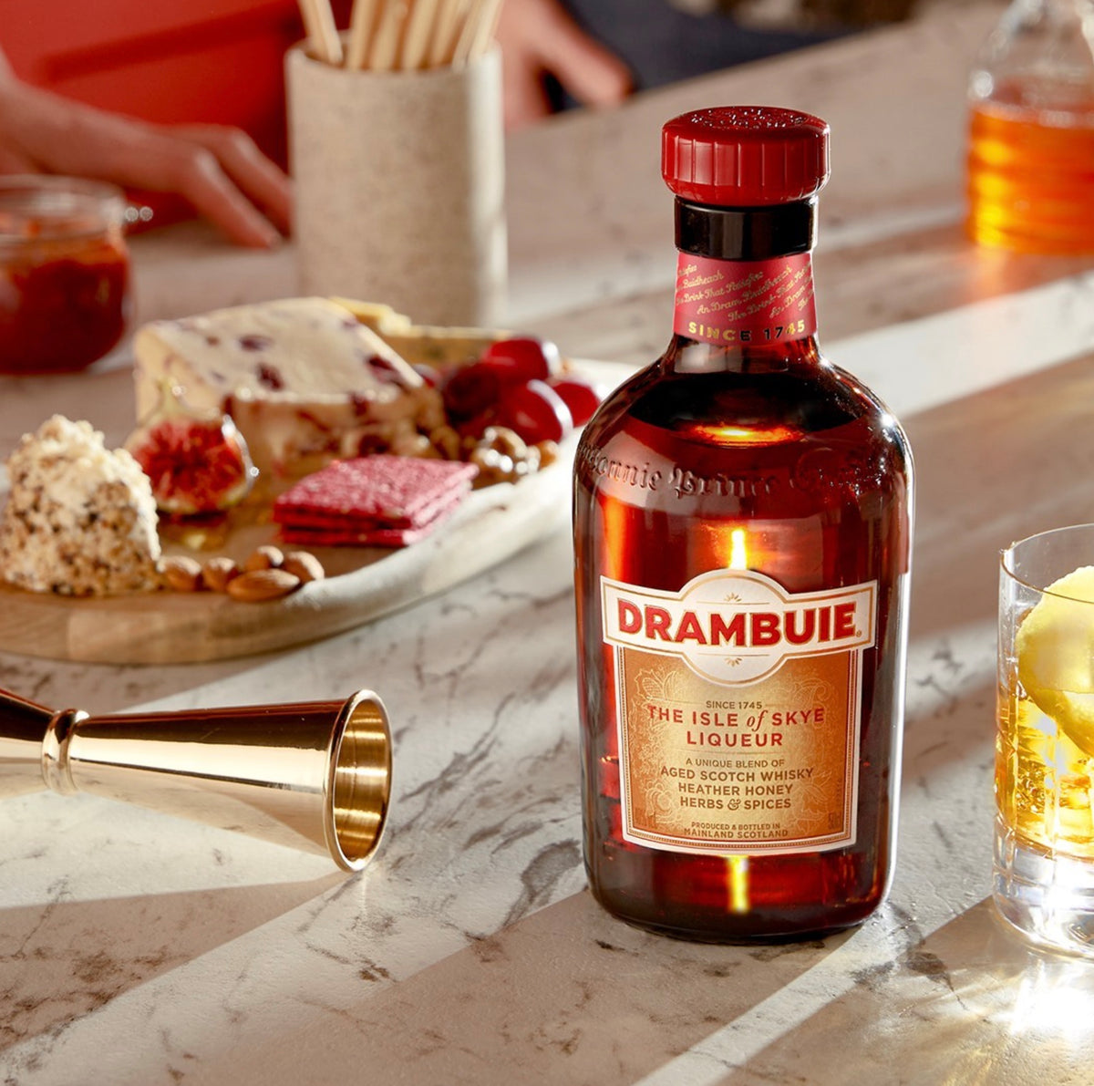 Drambuie The Isle of Skye Liqueur bottle, showcasing its Scotch whisky blend with herbs and honey, on a marble table.