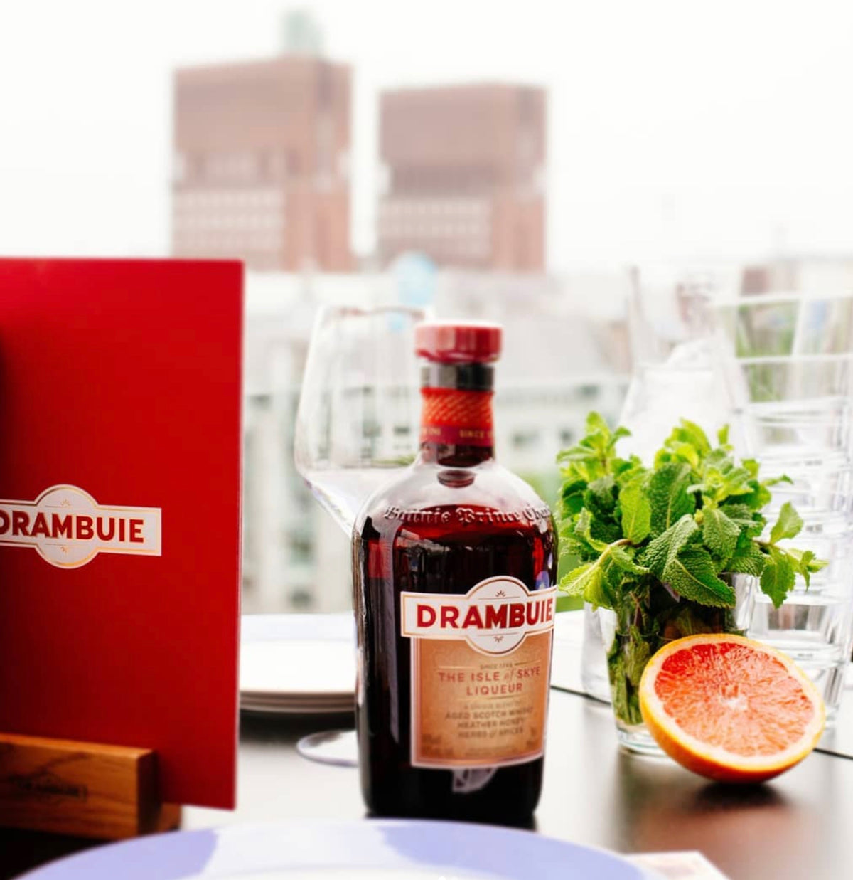 Drambuie The Isle of Skye Liqueur bottle with mint and orange slice on a dining table.