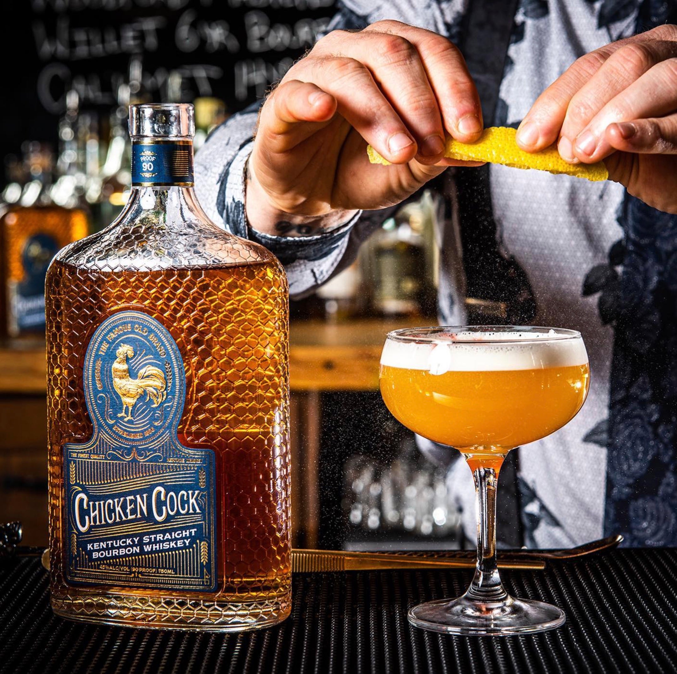 A bartender preparing a cocktail with Chicken Cock Kentucky Straight Bourbon and garnish, showcasing the whiskey's rich color.