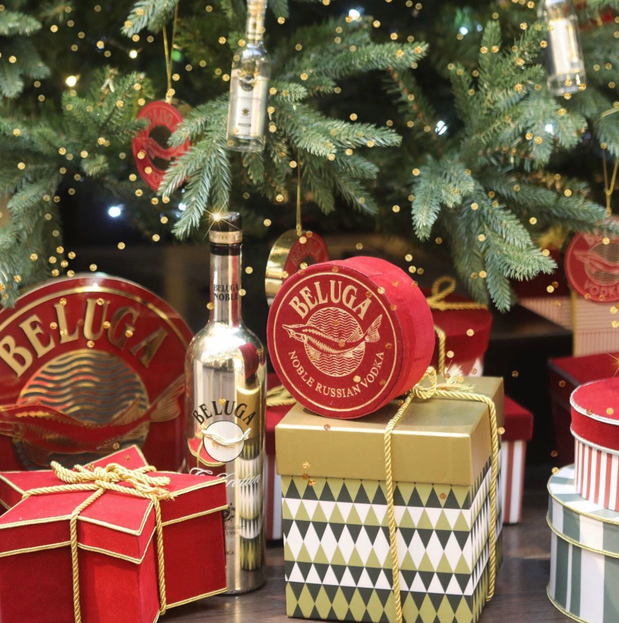 Beluga Noble Celebration Russian vodka bottle and festive gifts under a Christmas tree.