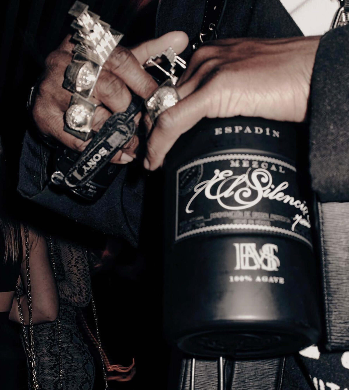 Close-up of El Silencio Espadín Mezcal bottle in a hand, showcasing its sleek design and 100% agave craftsmanship.