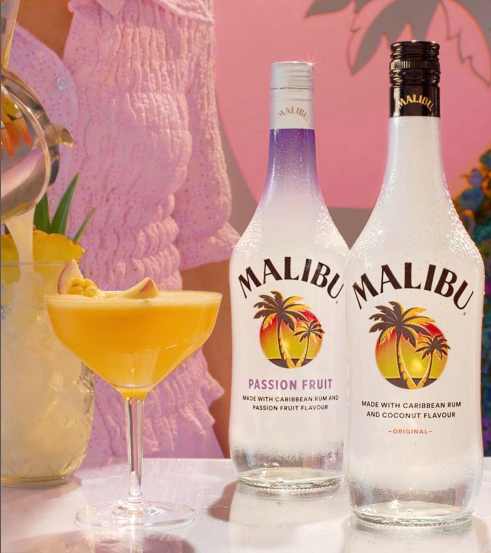 Chilled Malibu Passion Fruit and Original rum bottles beside a refreshing cocktail, perfect for summer gatherings.