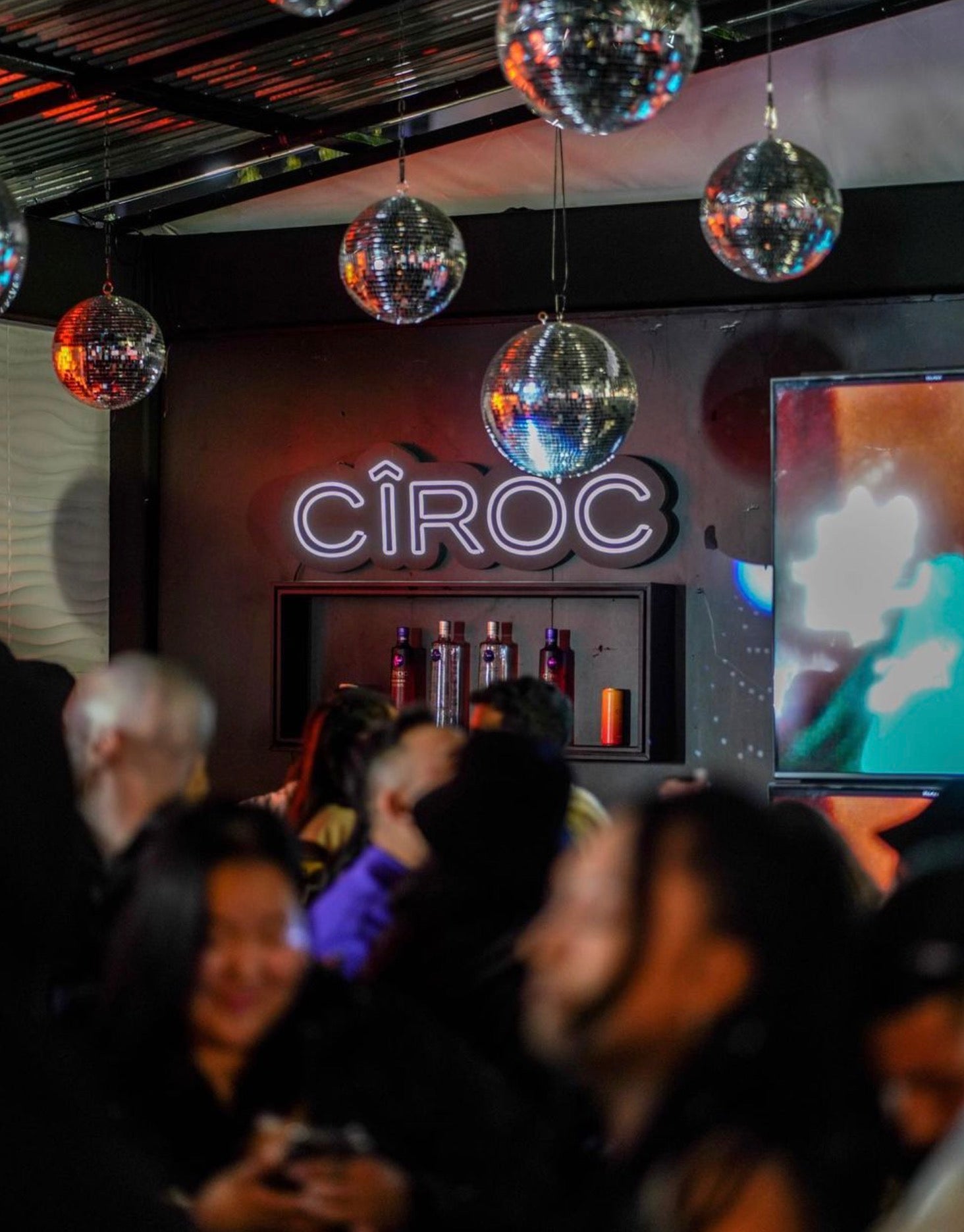 Ciroc vodka display at a vibrant event with disco balls and a lively crowd.