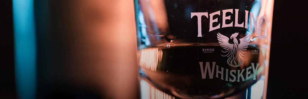 Teeling Blackpitts Peated Single Malt Irish Whisky in a glass, showcasing rich color and branding.