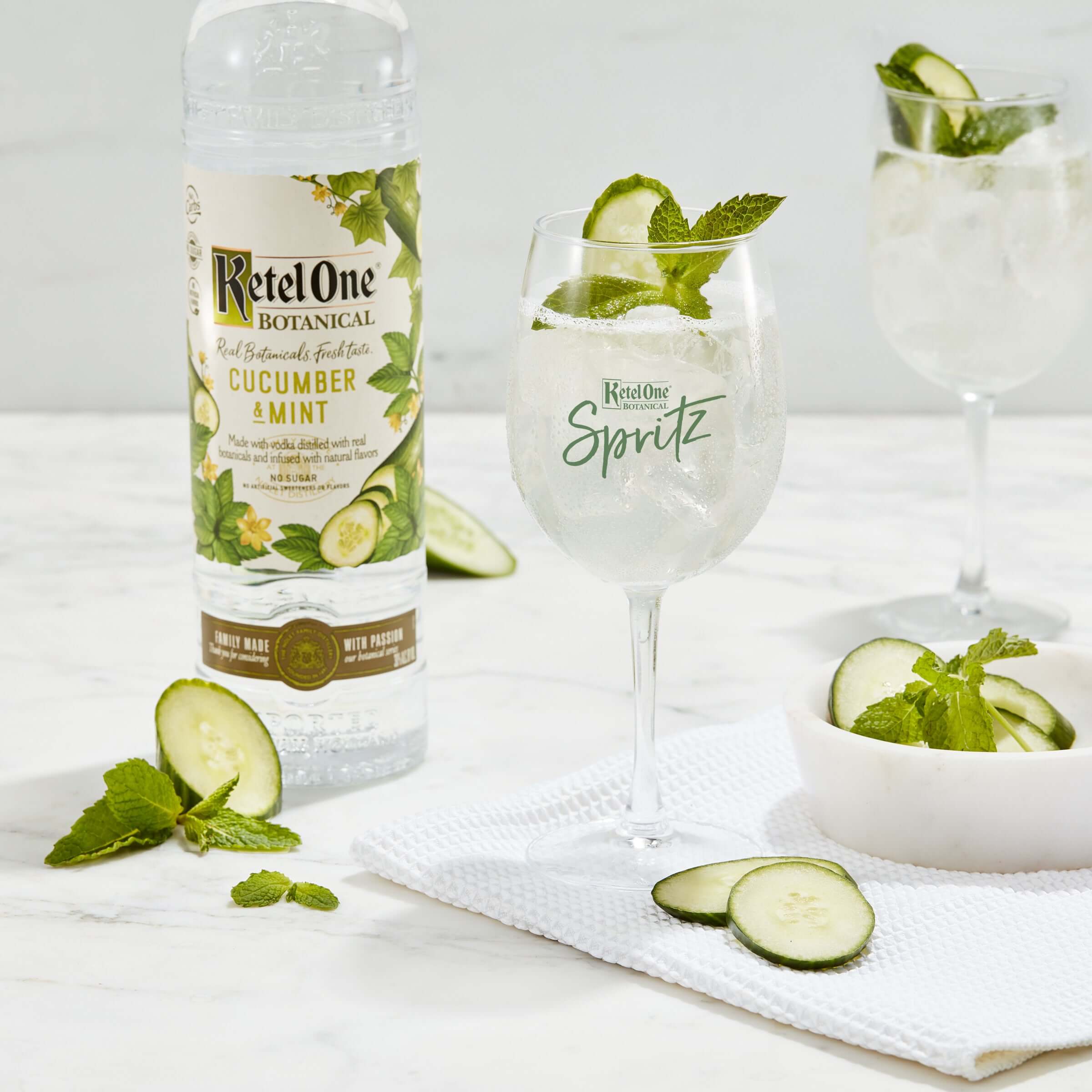 Refreshing Ketel One Botanical Cucumber & Mint cocktail served with cucumber slices and mint leaves.