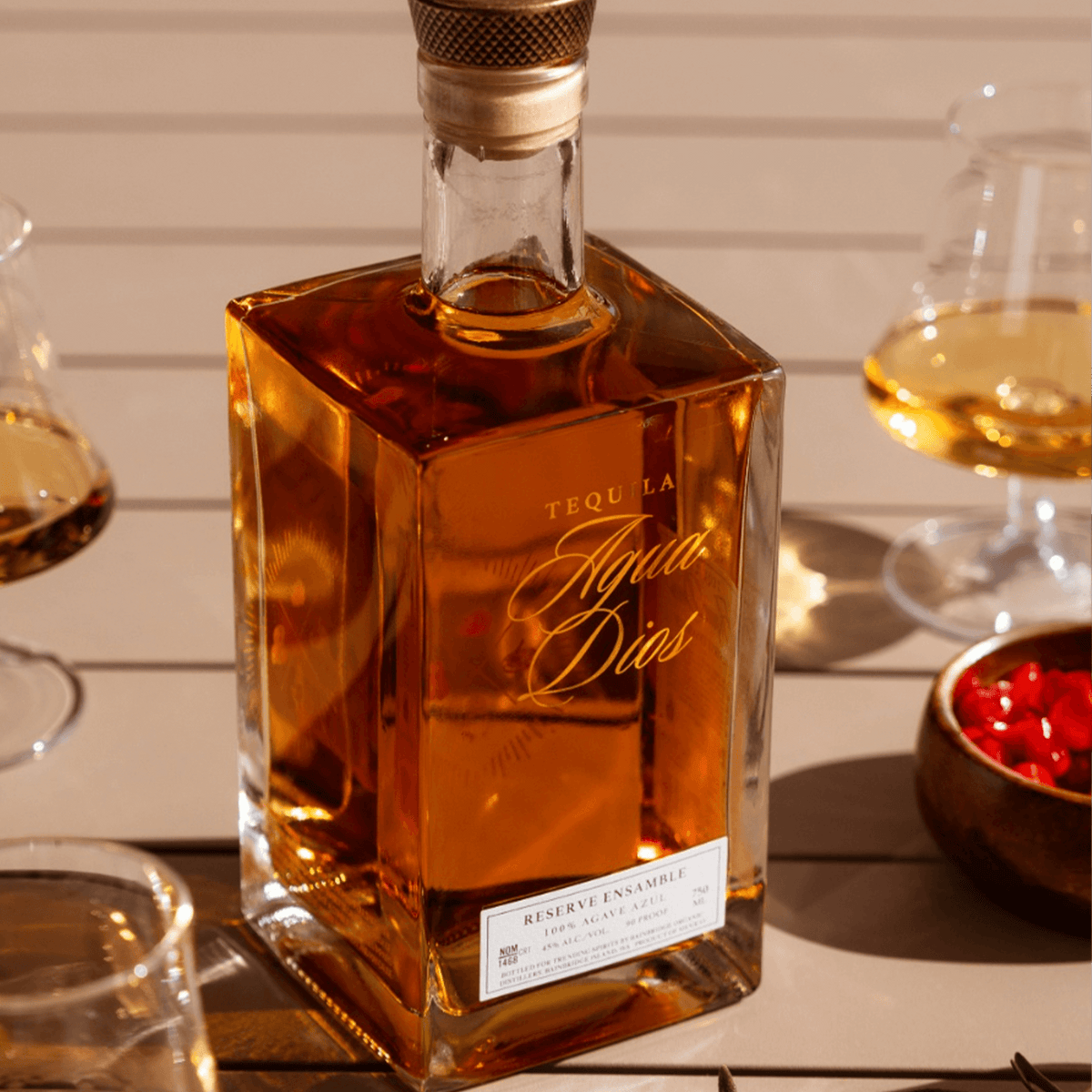 AguaDios 15 Year Reserve Ensemble Tequila bottle, aged in Japanese Mizunara Oak, on a rustic table.