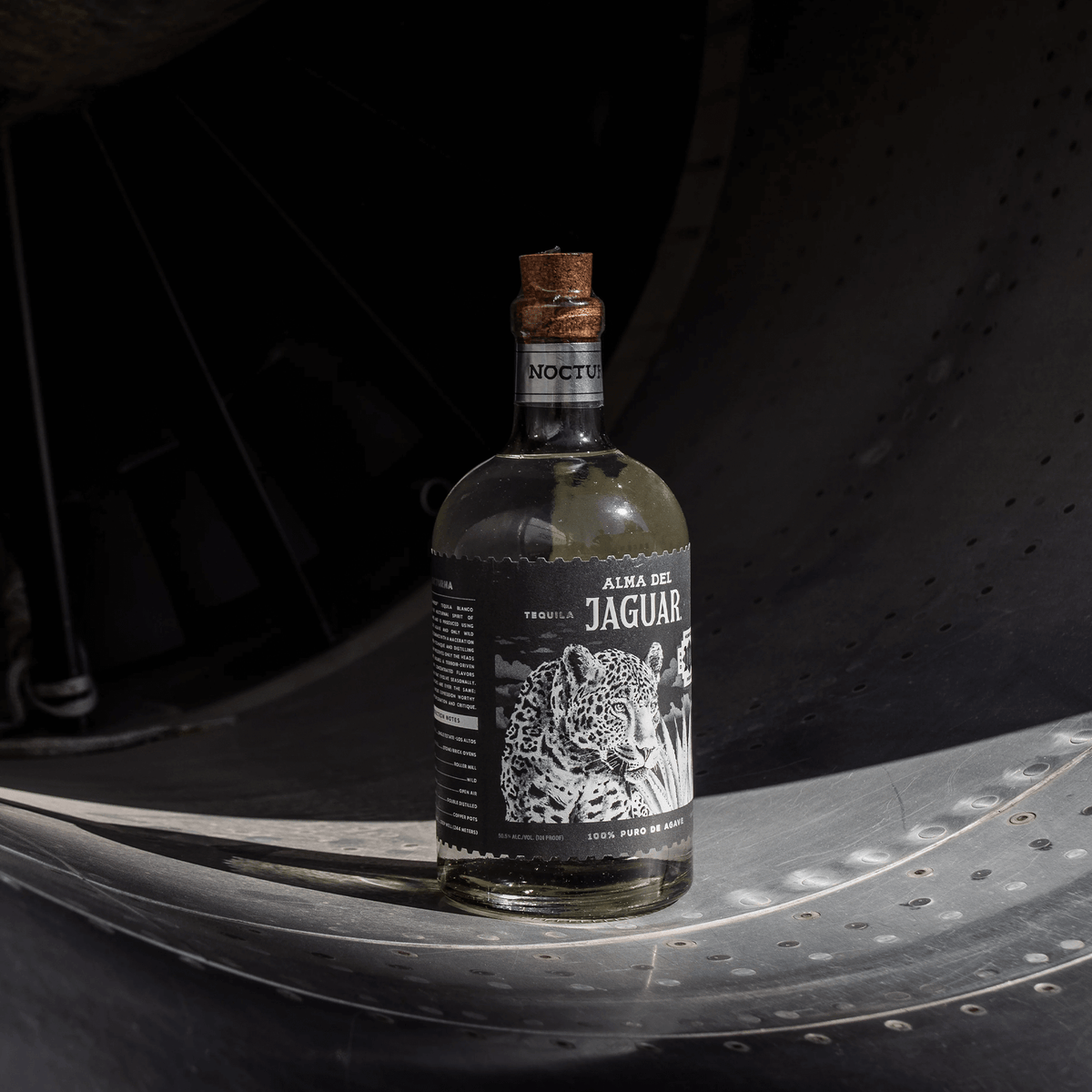 Alma del Jaguar Nocturna high proof blanco tequila bottle showcased in a unique industrial setting.