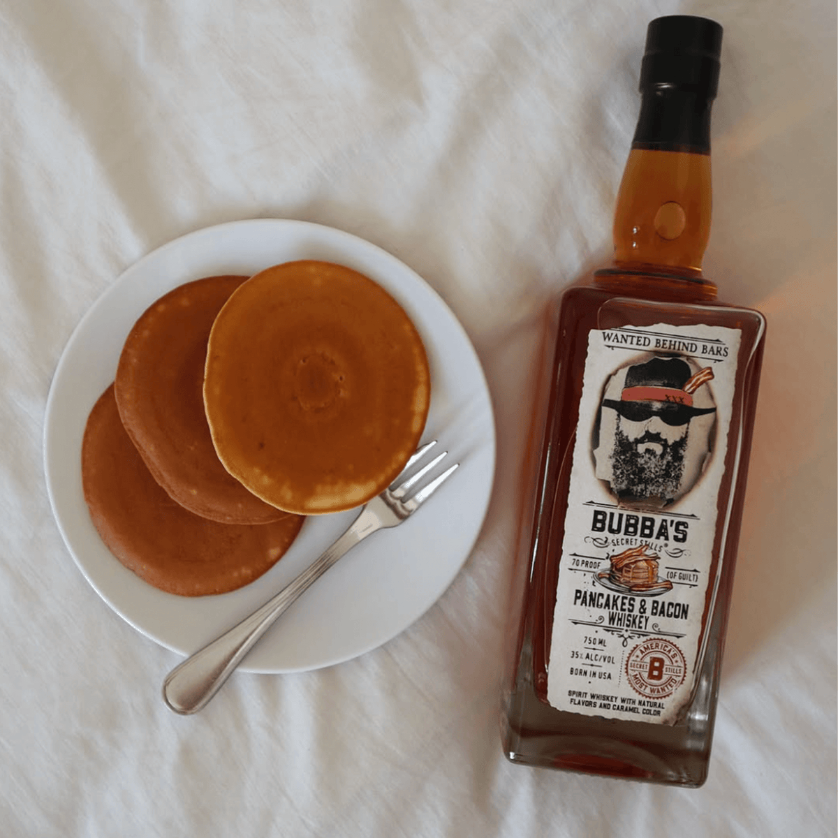 Bubba's Pancakes & Bacon Whiskey next to a plate of fluffy pancakes, perfect for game day celebrations.