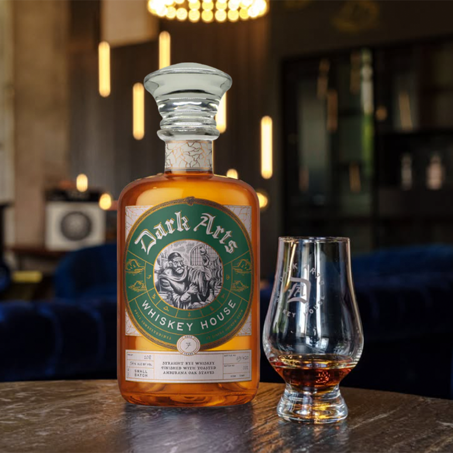 Dark Arts 7 Year Amburana Oak Staves Rye Whiskey bottle alongside a whiskey glass in a stylish setting.
