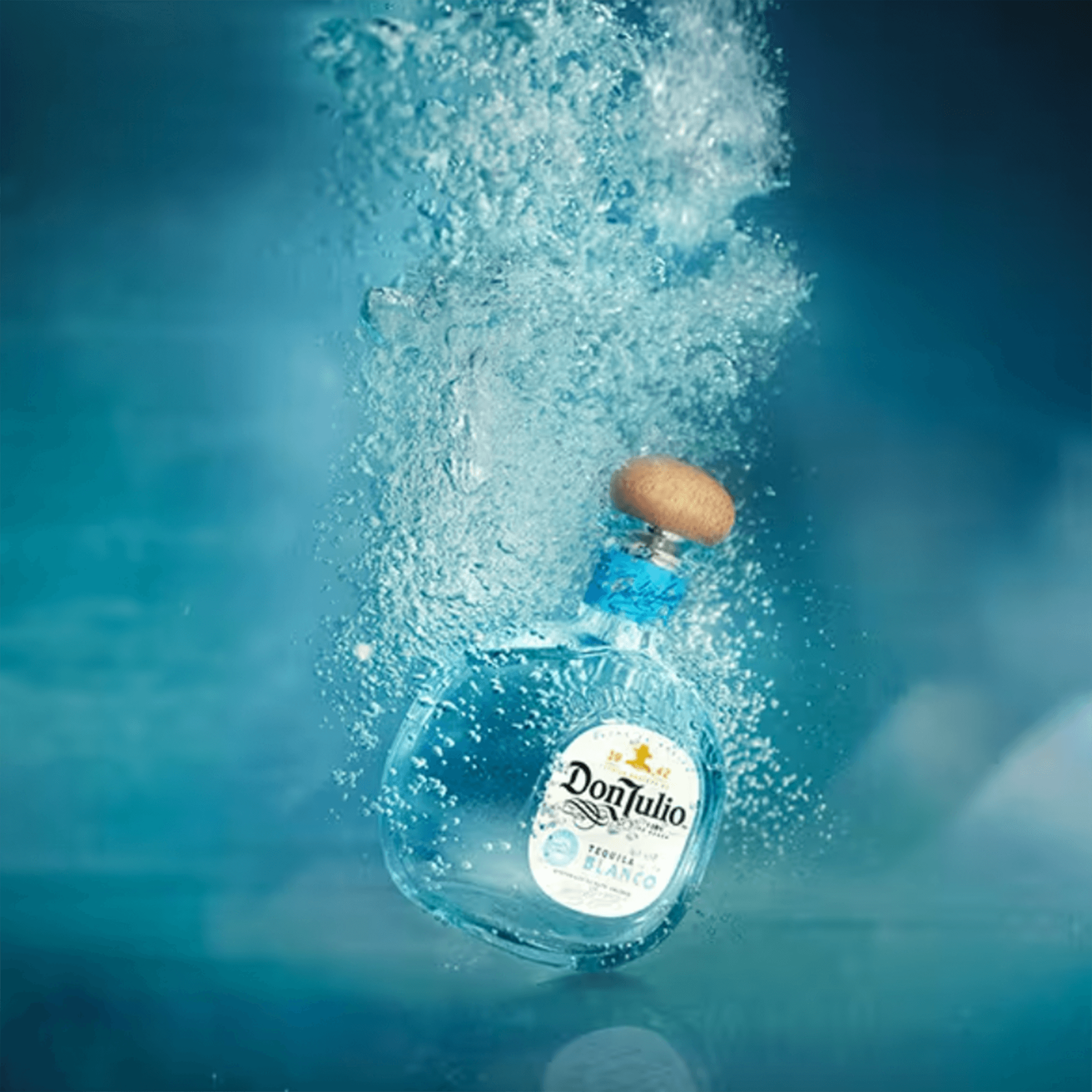 Don Julio Blanco Tequila 1L bottle splashing in water, showcasing its crisp agave flavor and silver quality.