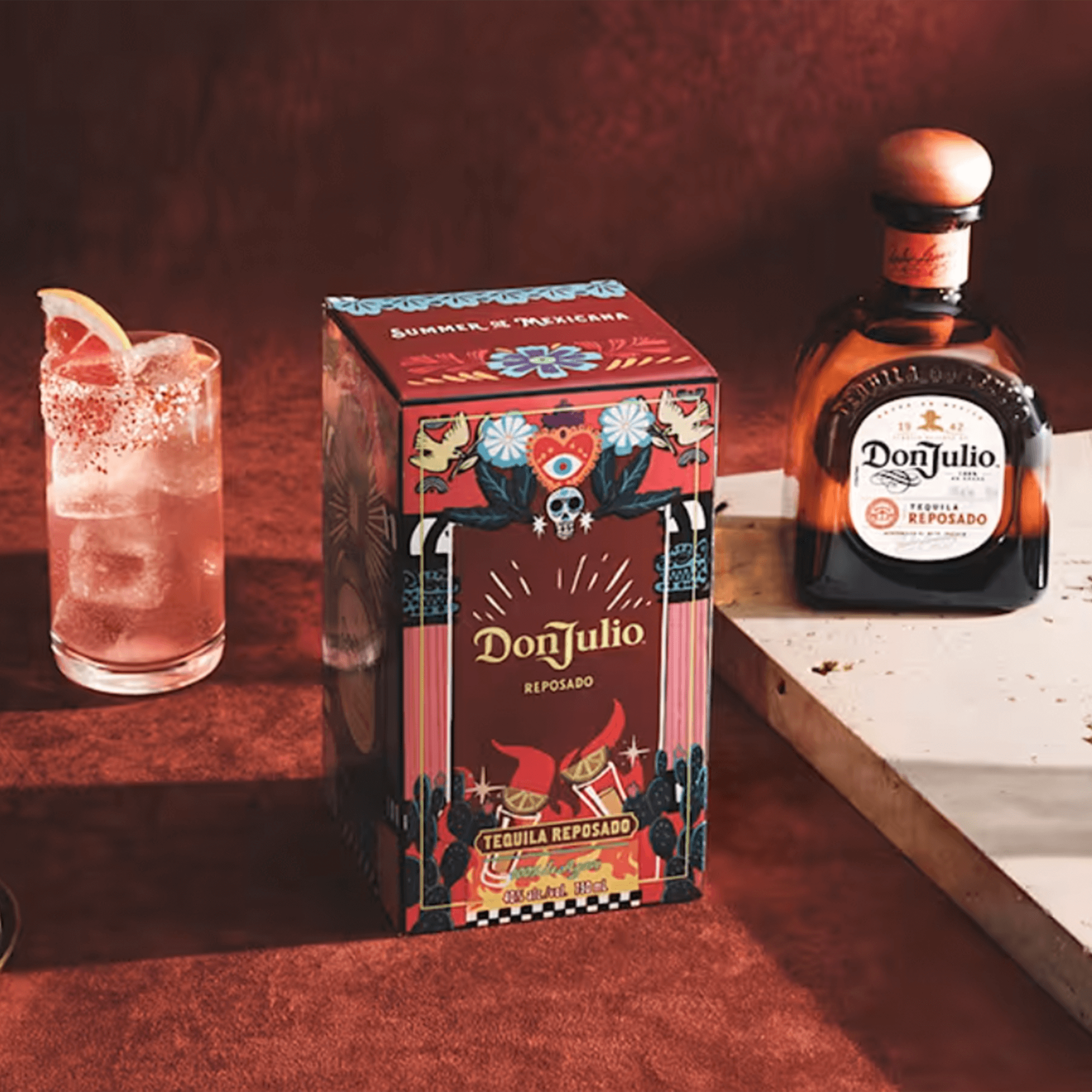 Don Julio Reposado Tequila bottle and box with a cocktail on a stylish surface, showcasing vibrant packaging.