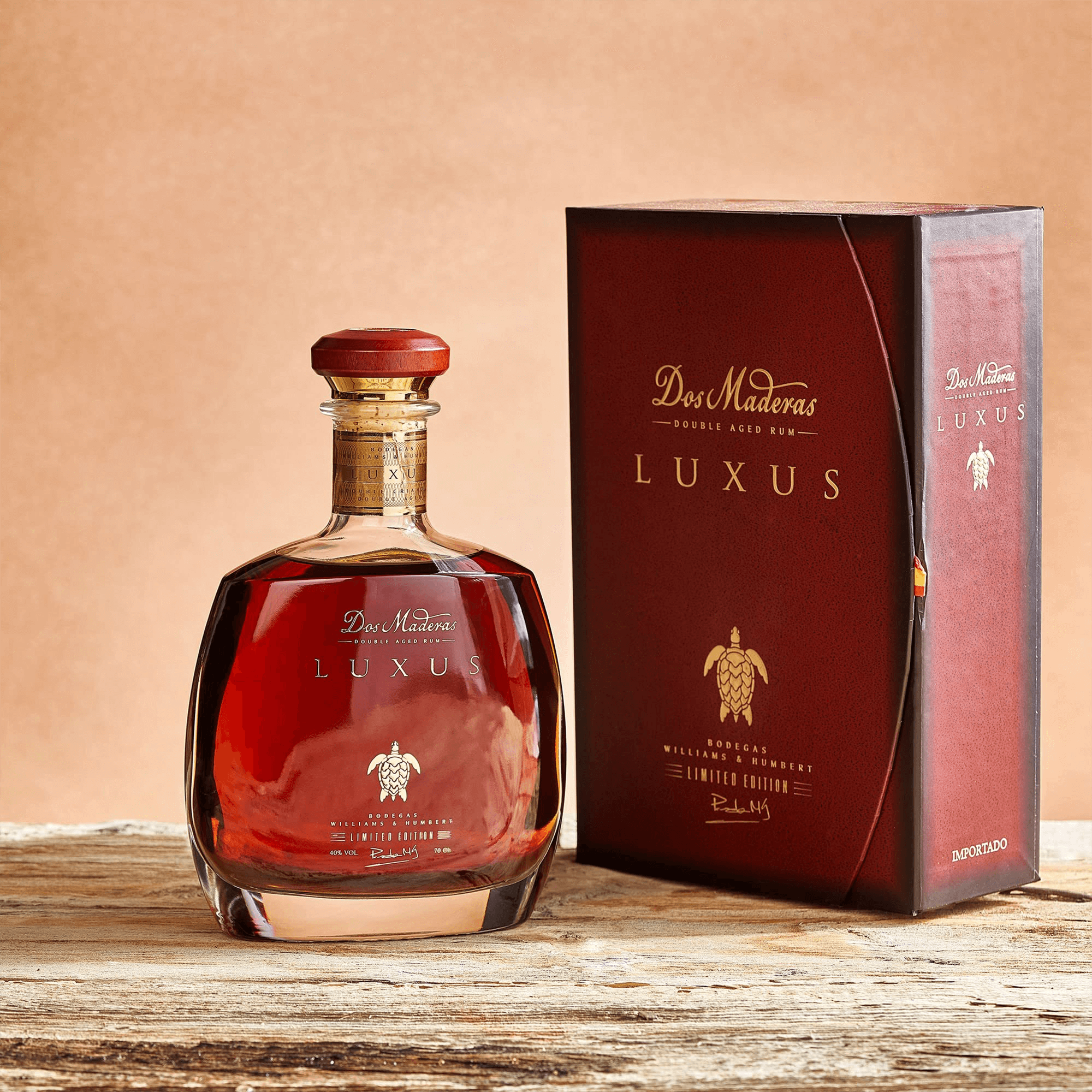 Dos Maderas Luxus Double Aged Rum 700ml in elegant bottle and packaging on rustic table, showcasing its rich color and luxurious design.
