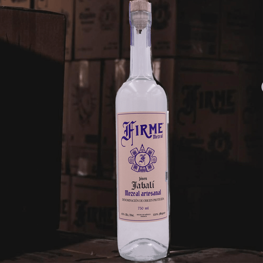 Firme Mezcal Joven Jabali bottle showcasing artisanal craftsmanship and 100% Agave Jabali, set against a rustic background.