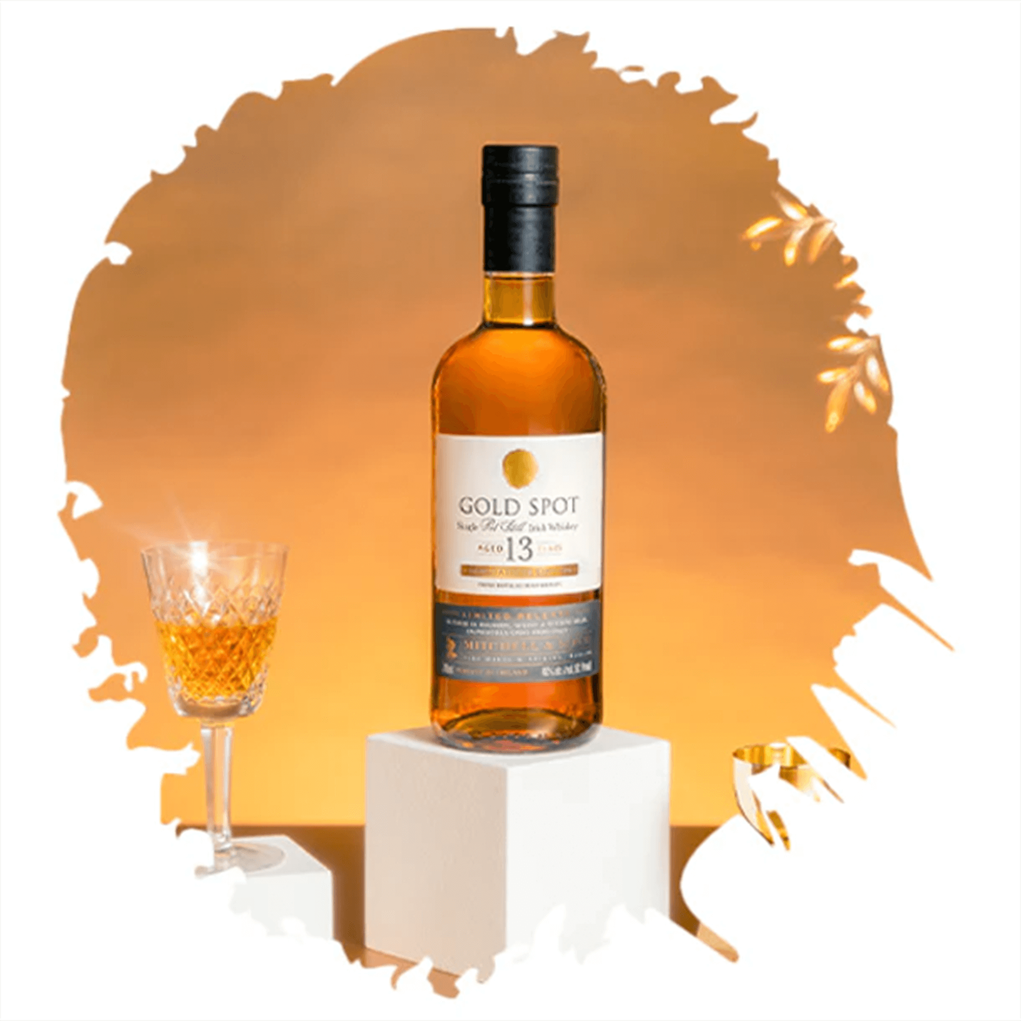 Gold Spot Limited Edition Single Pot Still Irish whiskey bottle with glass on a pedestal, showcasing rich amber color.
