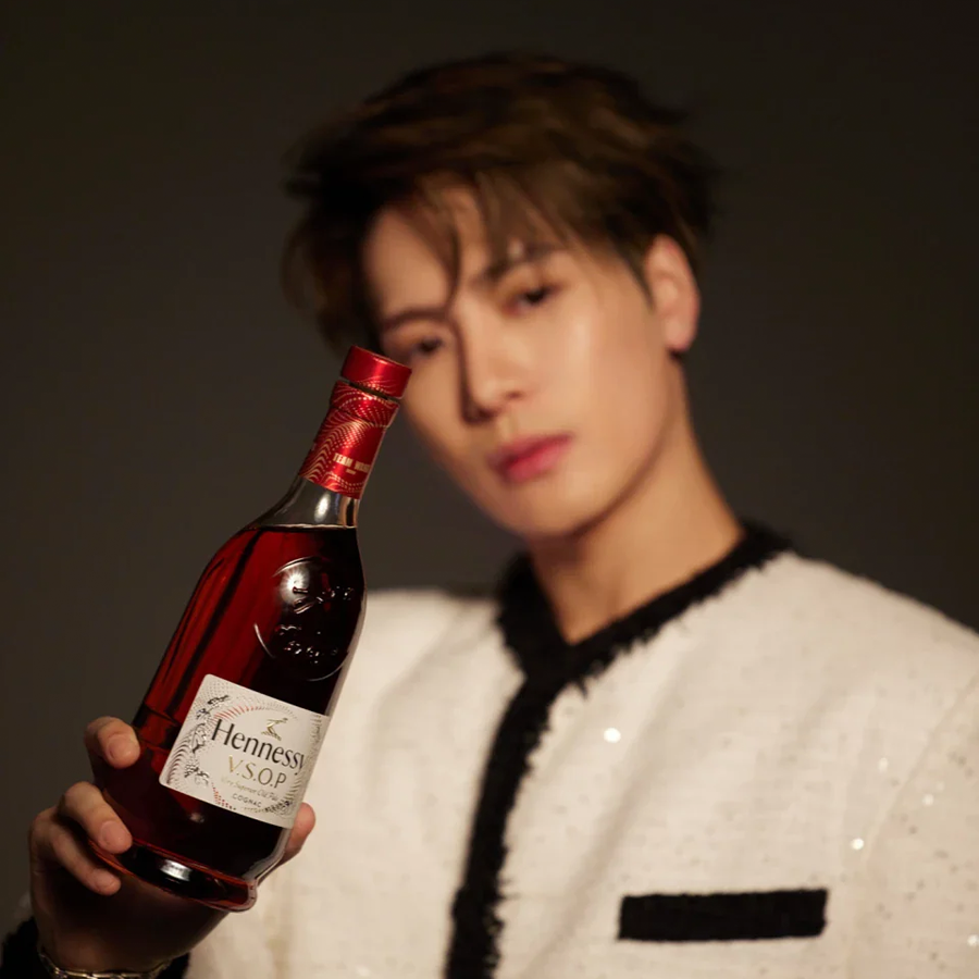 Hennessy VSOP X Team Wang bottle held by a model, showcasing the limited edition design in vibrant red and gold.