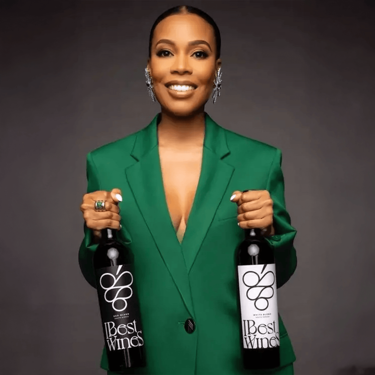 Model showcasing IBest Wines Art Red Blend bottles in a stylish green blazer, highlighting premium South African wine.