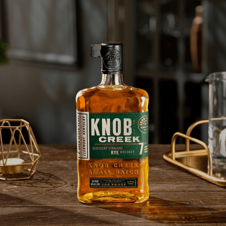 Knob Creek 7 Year Rye Whiskey bottle showcasing its rich amber color and distinctive label on a wooden table.
